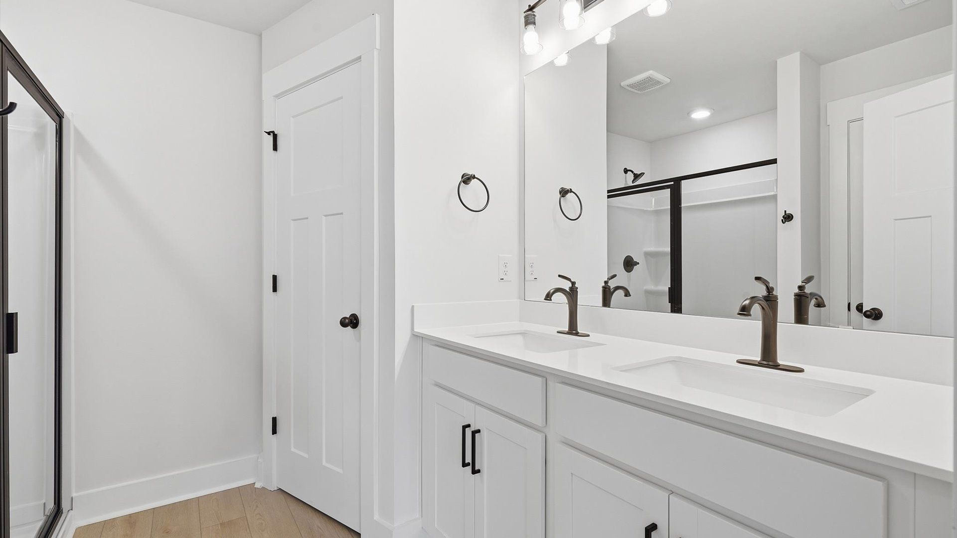 Elegant primary bathroom featuring a spacious walk-in shower and dual vanity in this first-class DRB Homes design