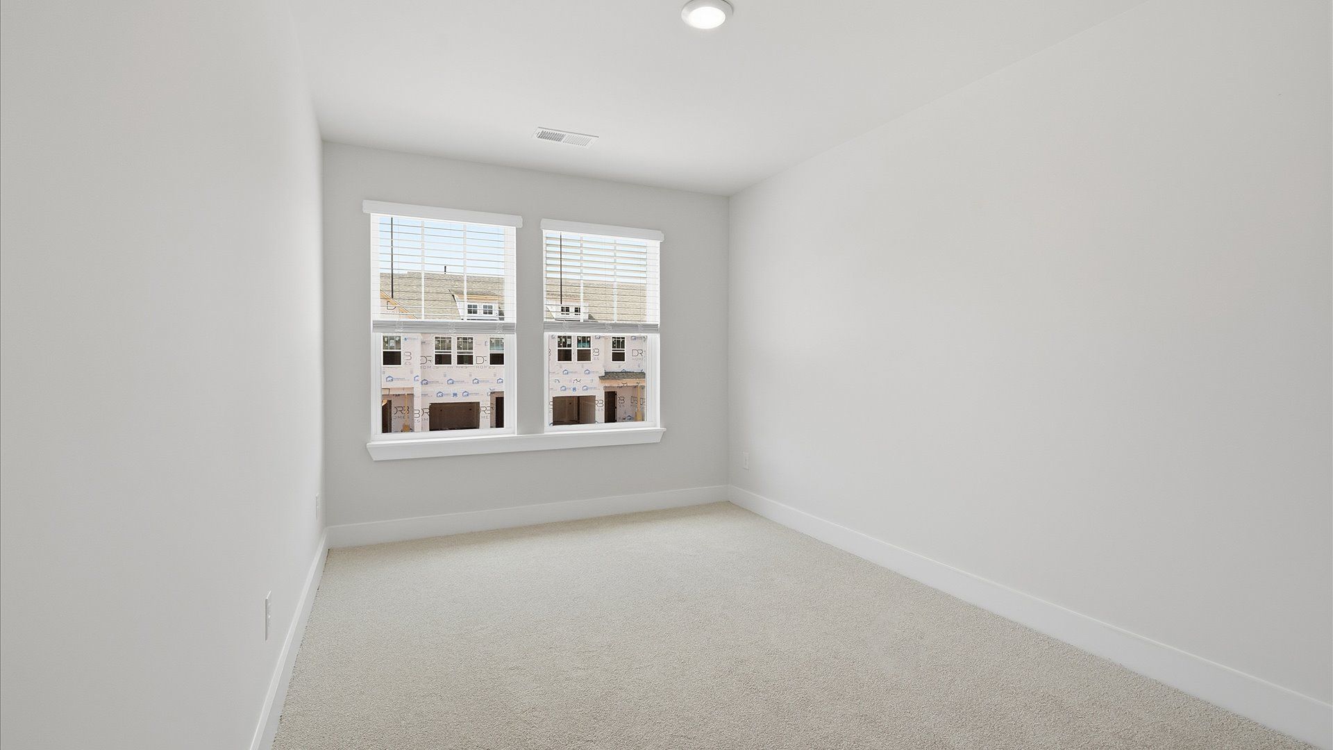 Elegant bedroom retreat featuring soft carpet and oversized windows that create a bright, welcoming space