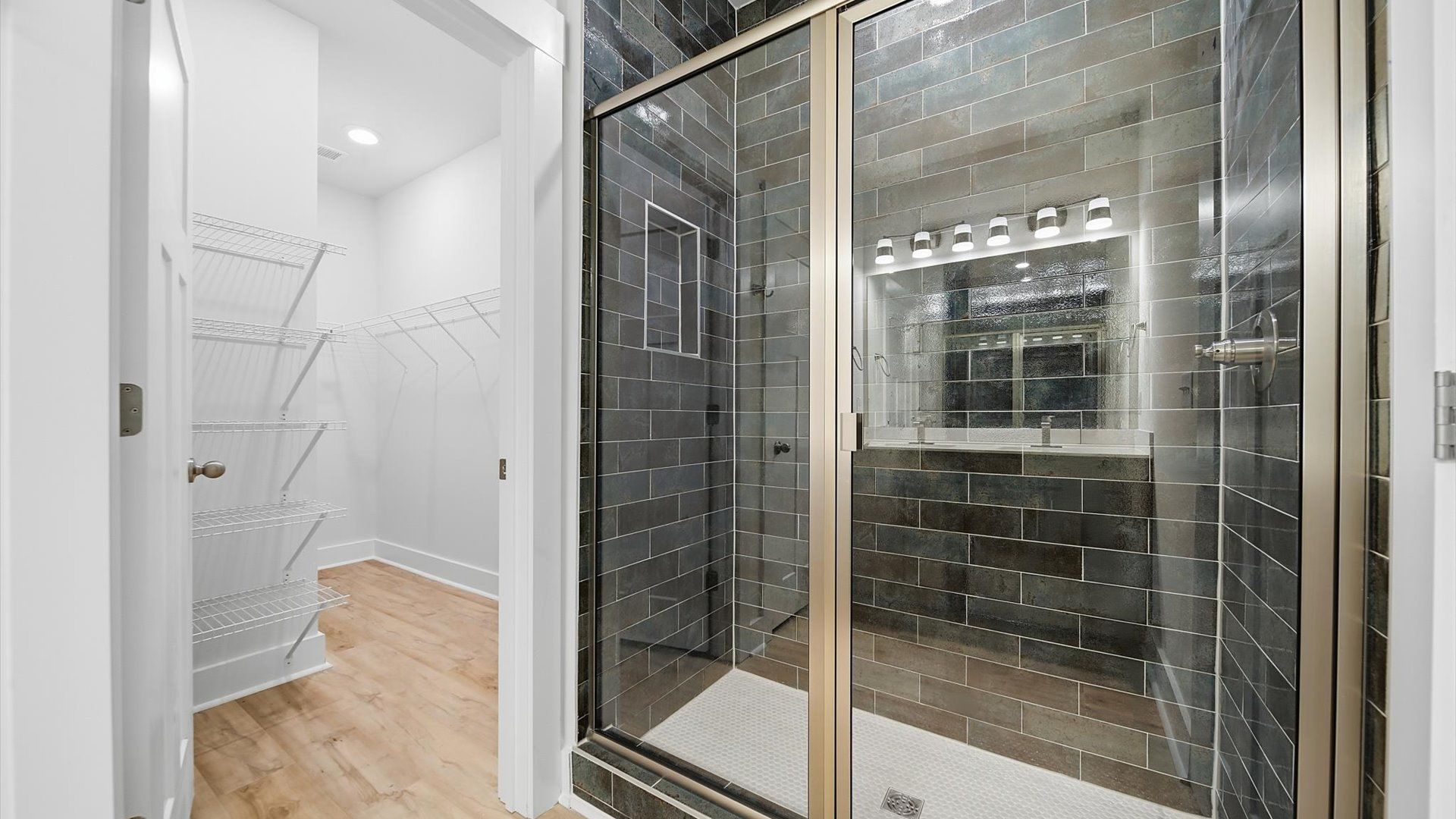 Elegant primary bathroom featuring a spacious walk-in shower and dual vanity in this first-class DRB Homes design