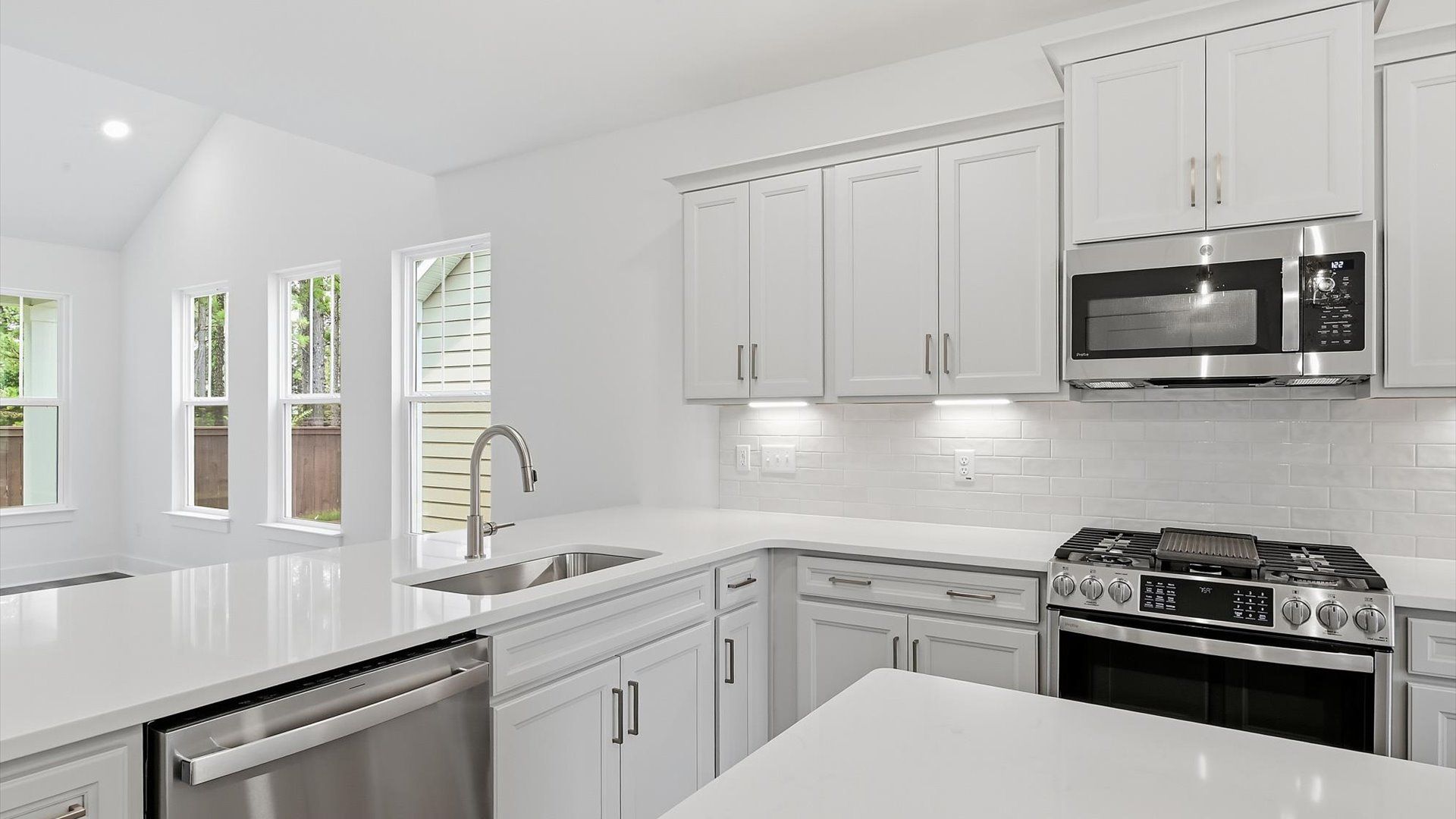 Highly skilled design choices create a clean, open kitchen with a central island