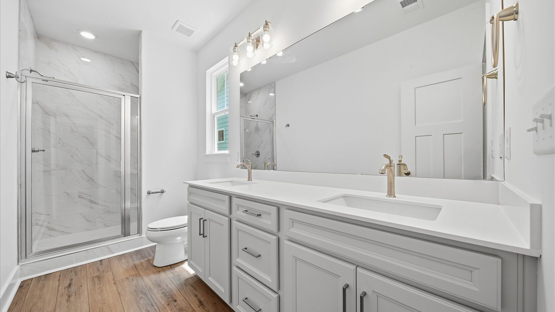 Superior en-suite primary bathroom with stylish dual vanity and tiled walk-in shower—crafted with high standards in mind