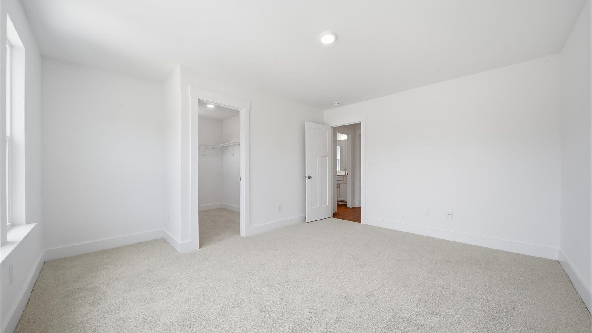 Highly functional bedroom with walk-in closet and tasteful carpet for a restful retreat