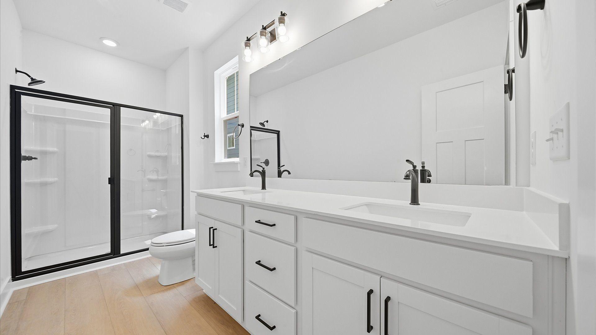Elegant primary bathroom featuring a spacious walk-in shower and dual vanity in this first-class DRB Homes design