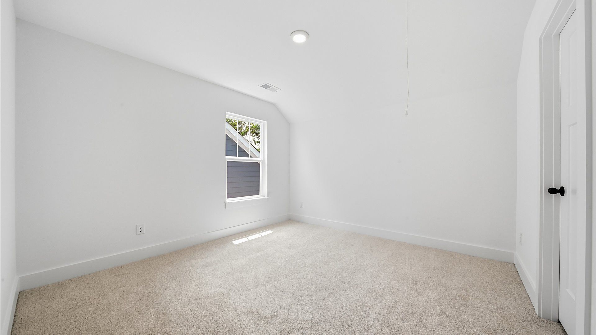 Elegant bedroom retreat featuring soft carpet and oversized windows that create a bright, welcoming space