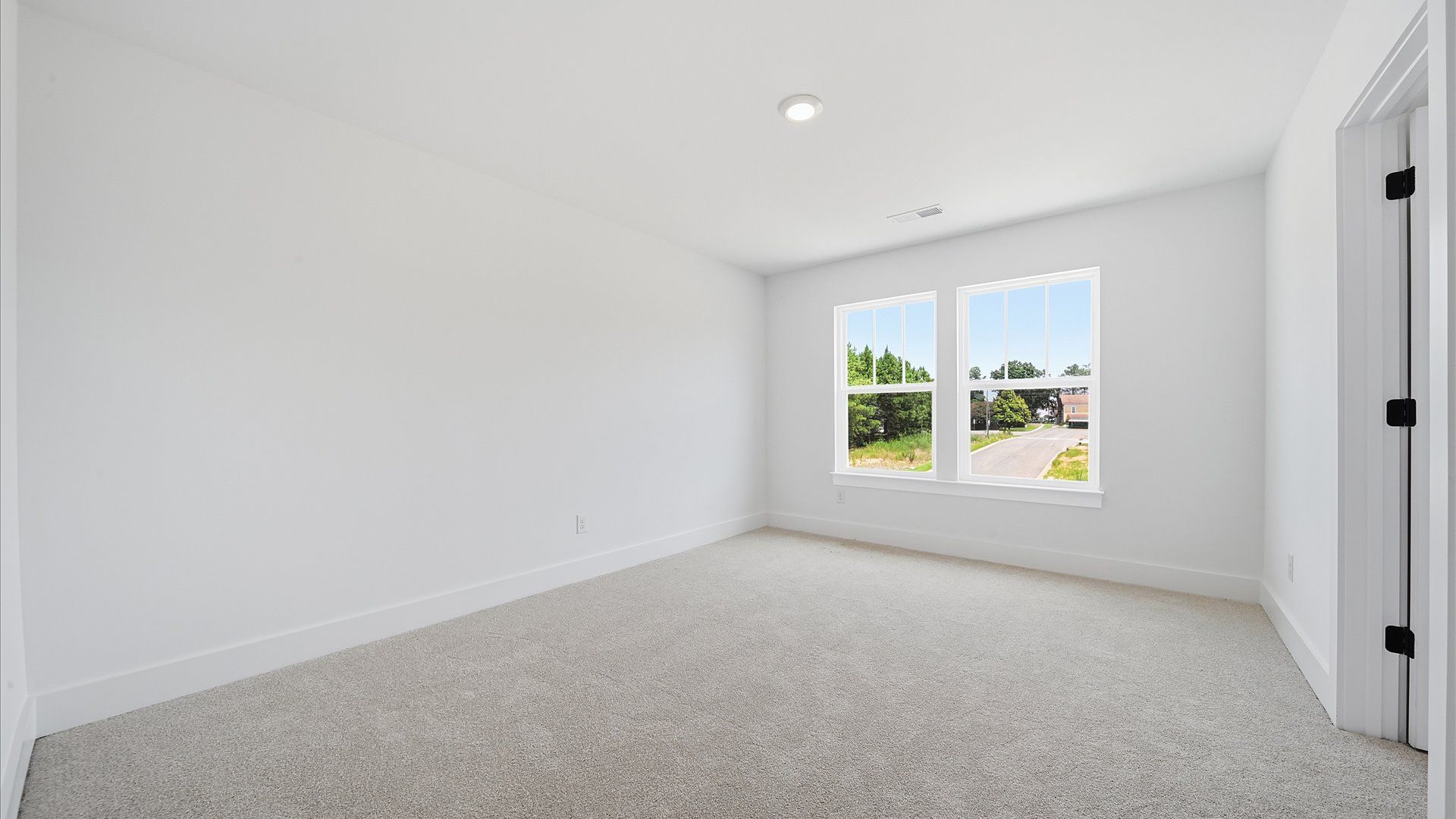 Superior comfort in this light-filled bedroom with plush carpeting and thoughtfully placed large windows