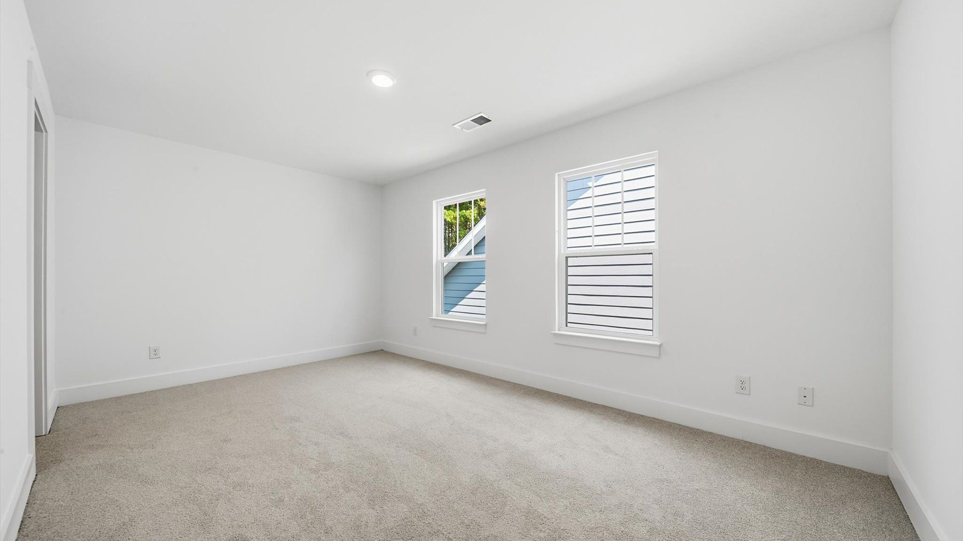 Superior comfort in this light-filled bedroom with plush carpeting and thoughtfully placed large windows