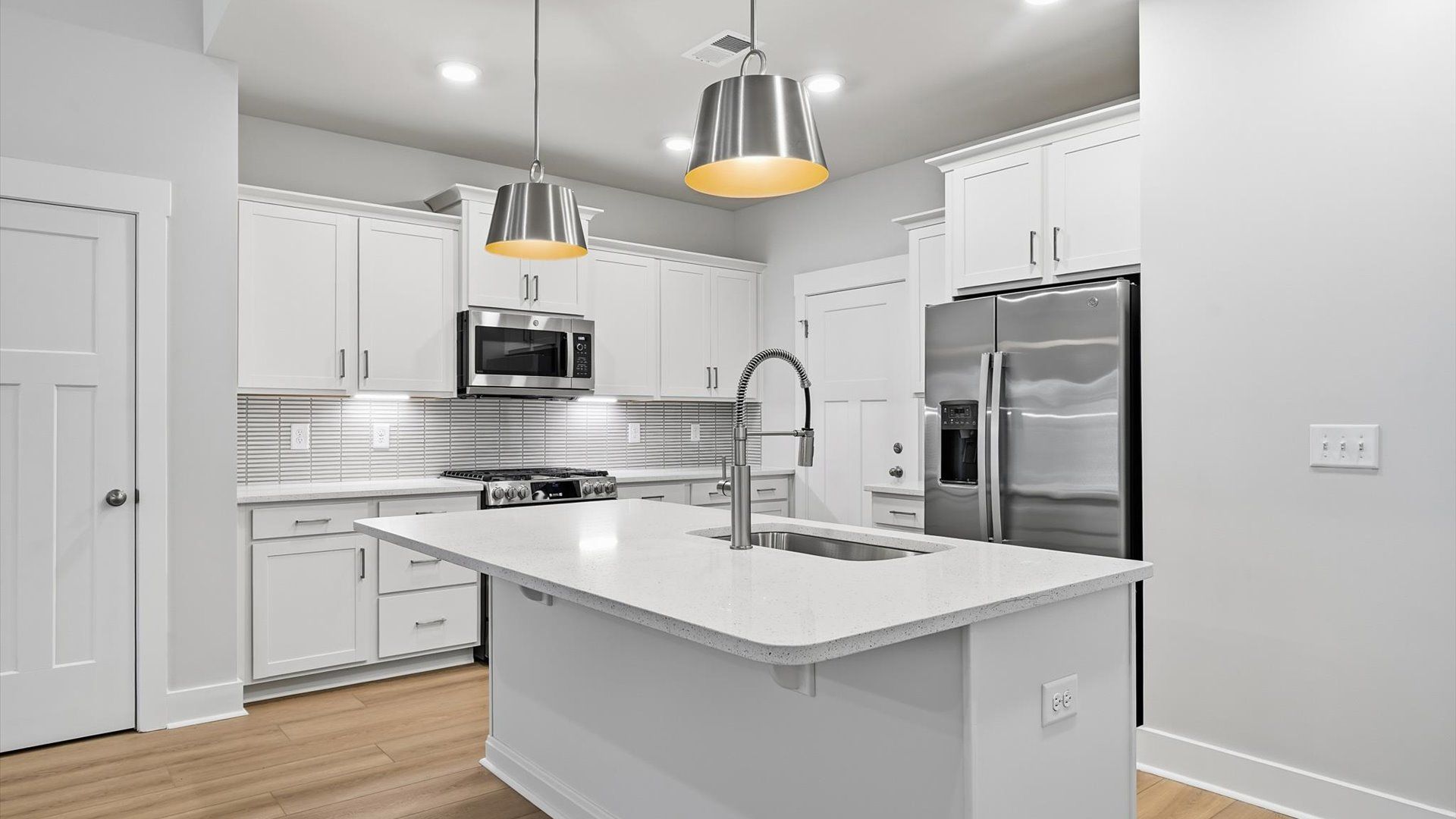 Memorable meals begin in this vibrant kitchen with pendant lighting and a thoughtfully designed island