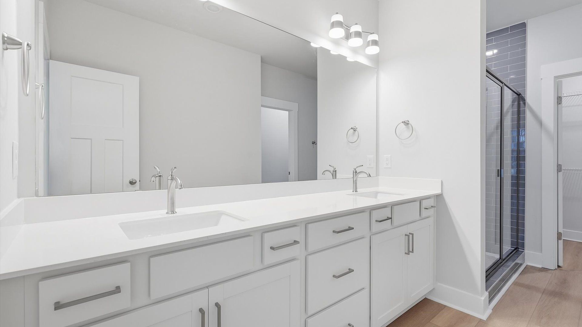 Exceptional en-suite with dual vanity and glass-enclosed tiled  walk-in shower for superior everyday comfort