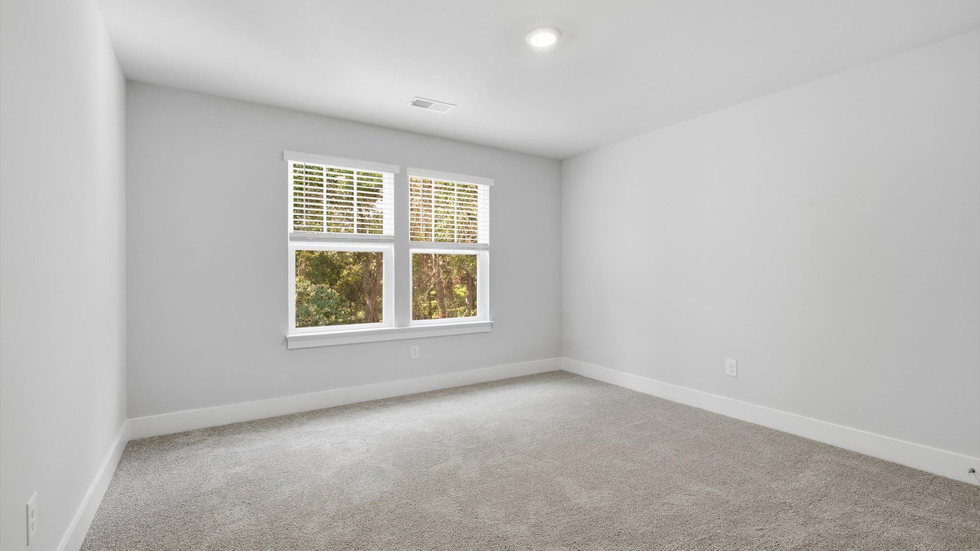 First-class secondary bedroom with comfortable carpeted flooring and generous closet space