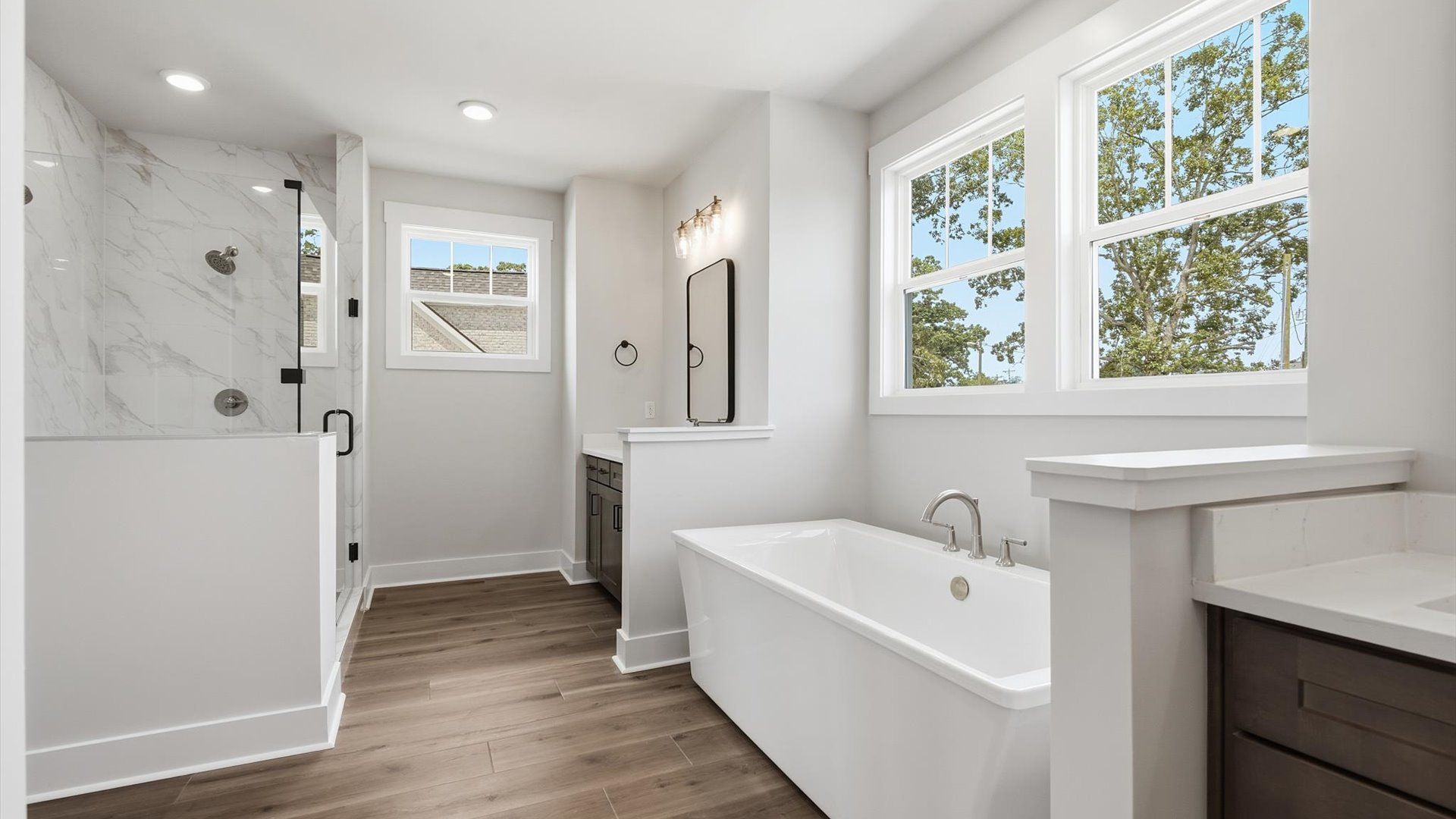 Highly functional and elegant en-suite with separate vanities, tiled walk-in shower,  soaking tub, and refined finishes
