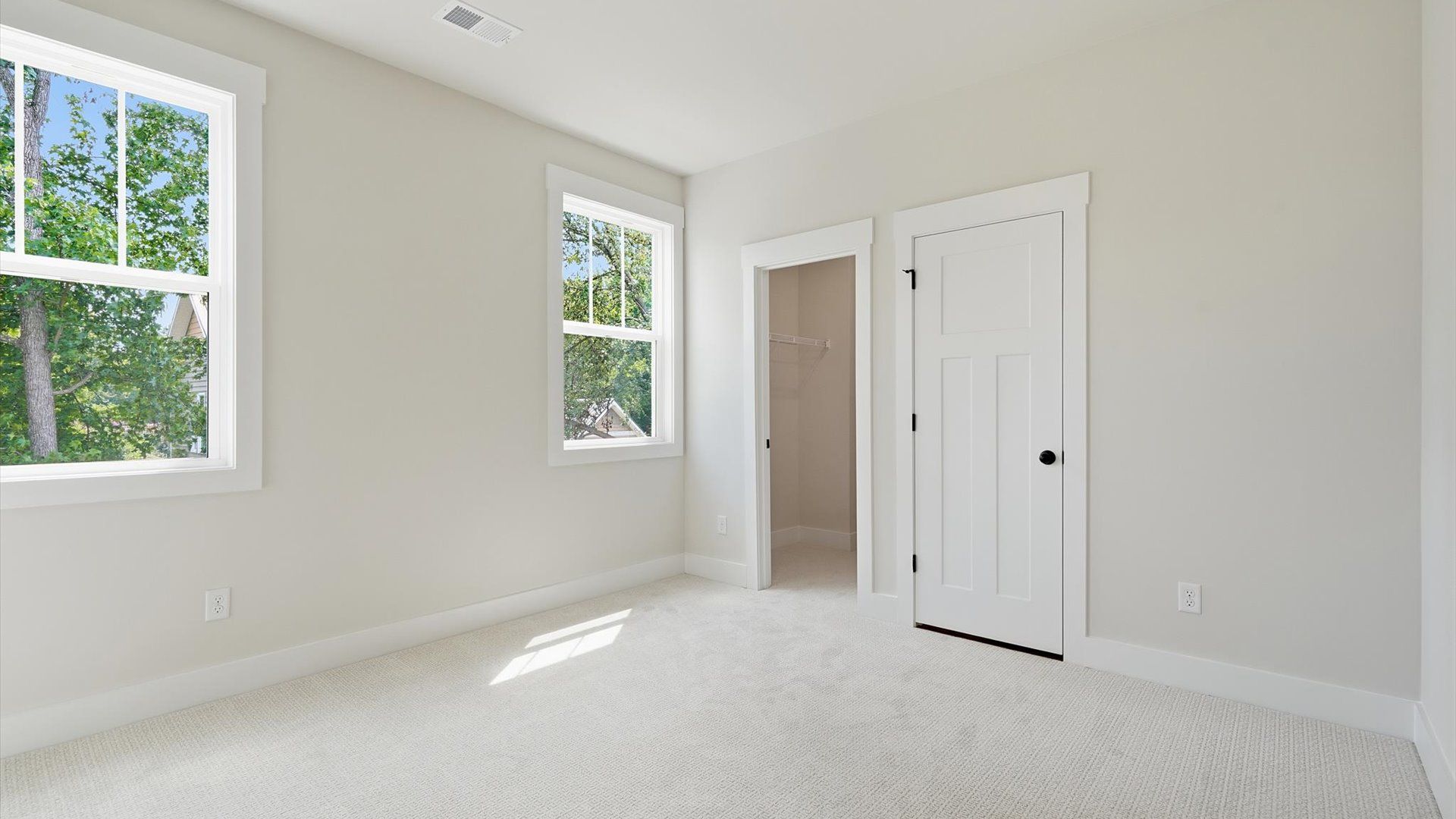 First-class bedroom with generous proportions, a walk-in closet, and beautiful natural light through large windows