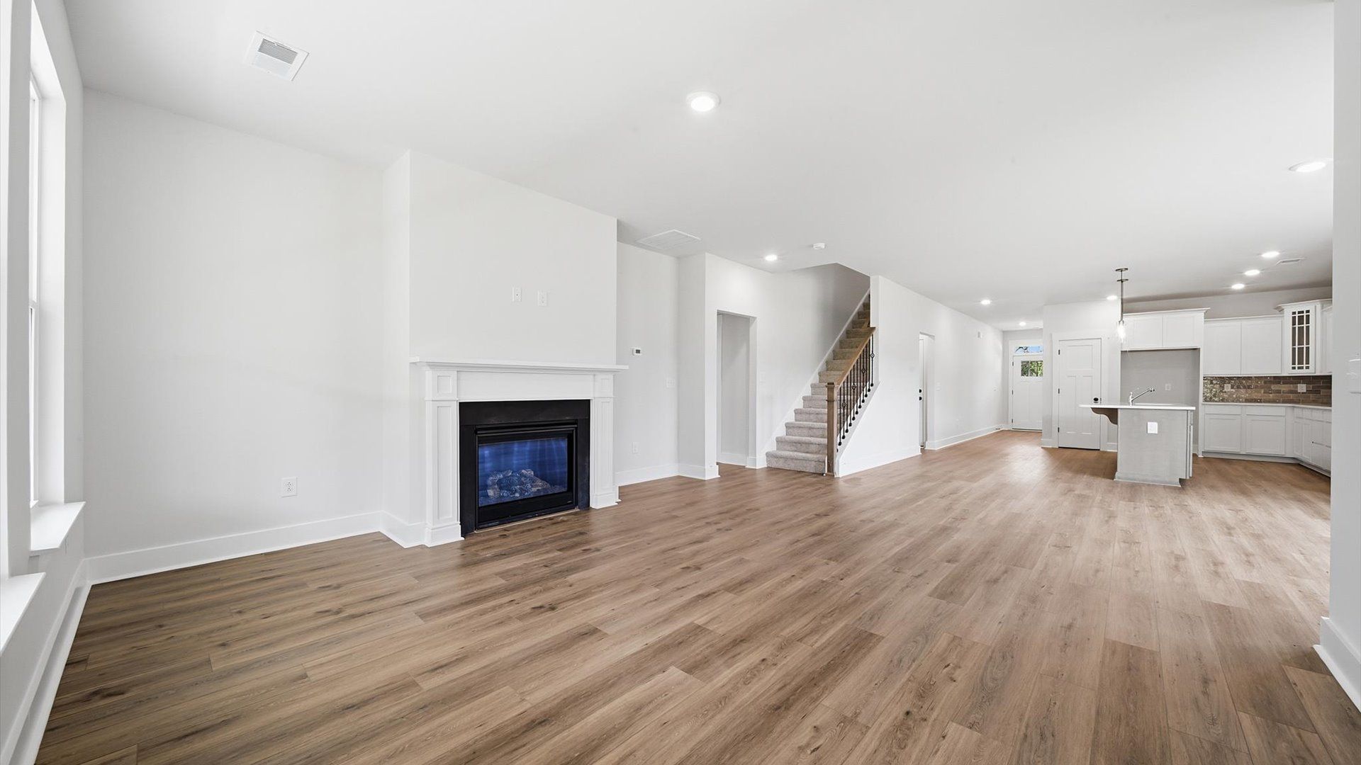 Elegant family room featuring hardwood flooring, large windows, and thoughtful architectural detail