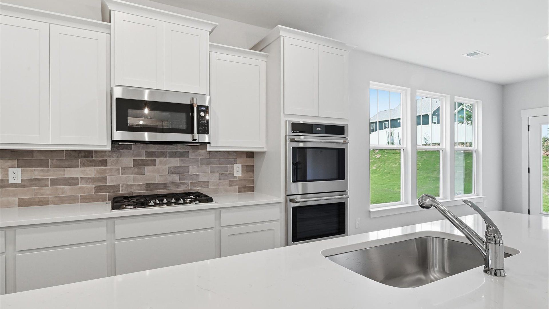 Memorable meals begin in this vibrant kitchen with pendant lighting and a thoughtfully designed island at Creeks at Midway