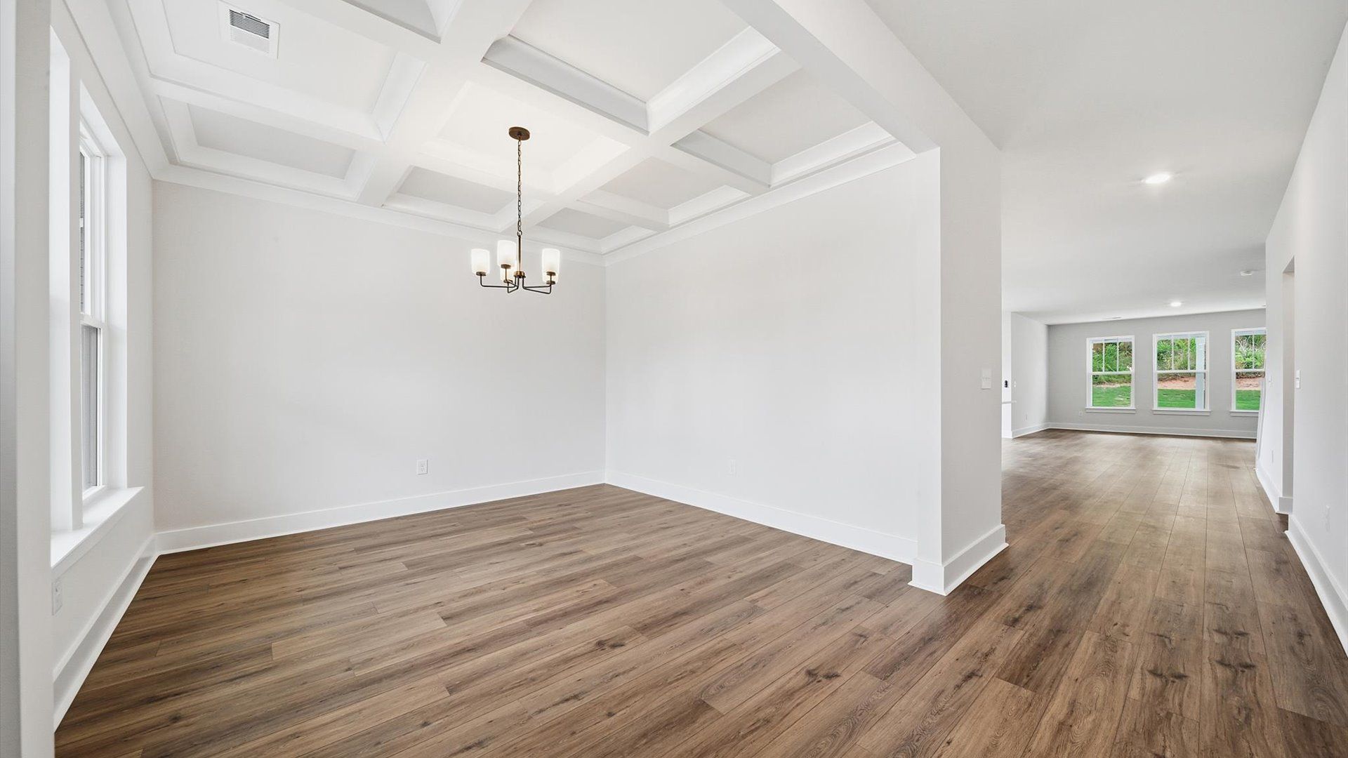 Tasteful coffered ceiling highlights the high standards of this vibrant DRB Homes dining room