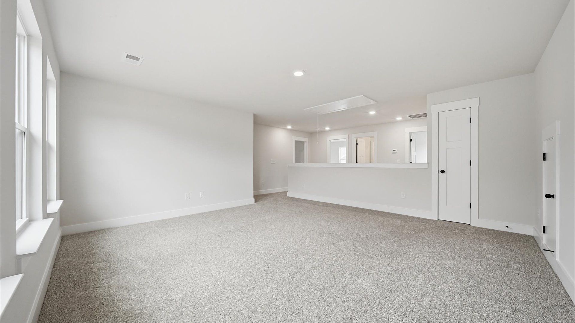 Vibrant carpeted loft offering flexibility as a study nook, game room, or second family space by DRB Homes