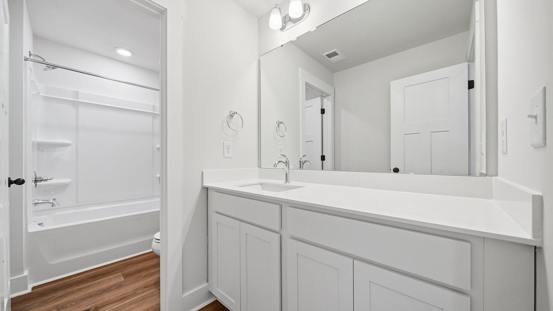Accomplished bathroom design with sleek tile, high-quality cabinetry, and refined hardware at Creeks at Midway