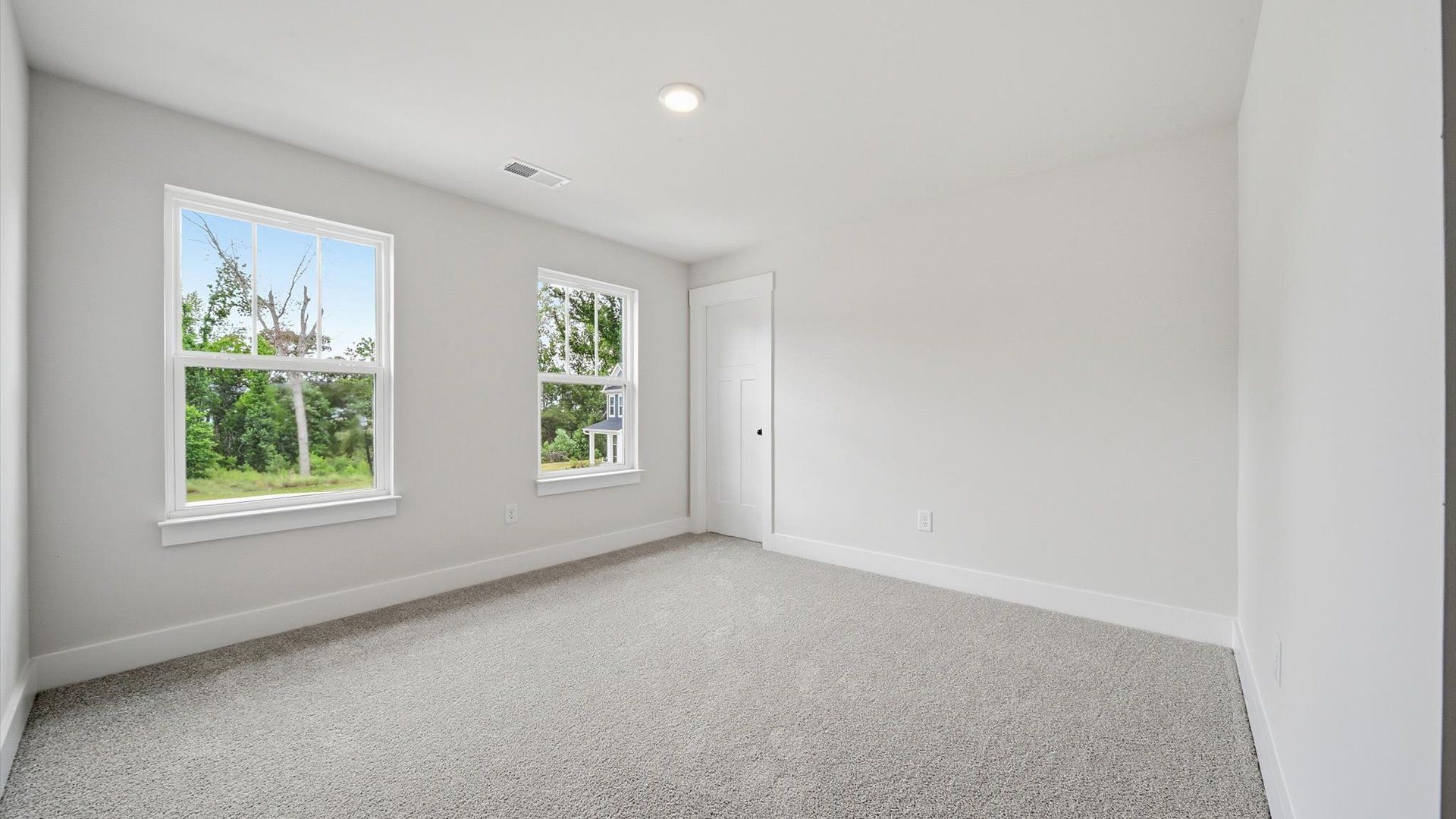 Tasteful bedroom with plush carpet, a walk-in closet, and large windows for abundant natural light in Anderson, SC