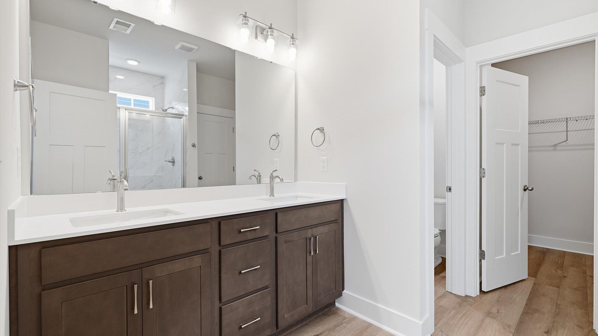 Superior en-suite primary bathroom with stylish dual vanity and tiled walk-in shower—crafted with high standards in mind