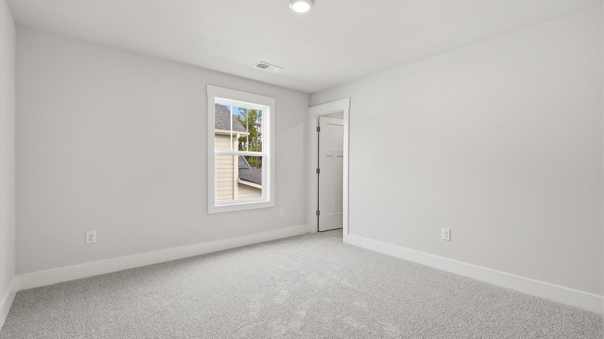 Elegant bedroom retreat featuring soft carpet and oversized windows that create a bright, welcoming space