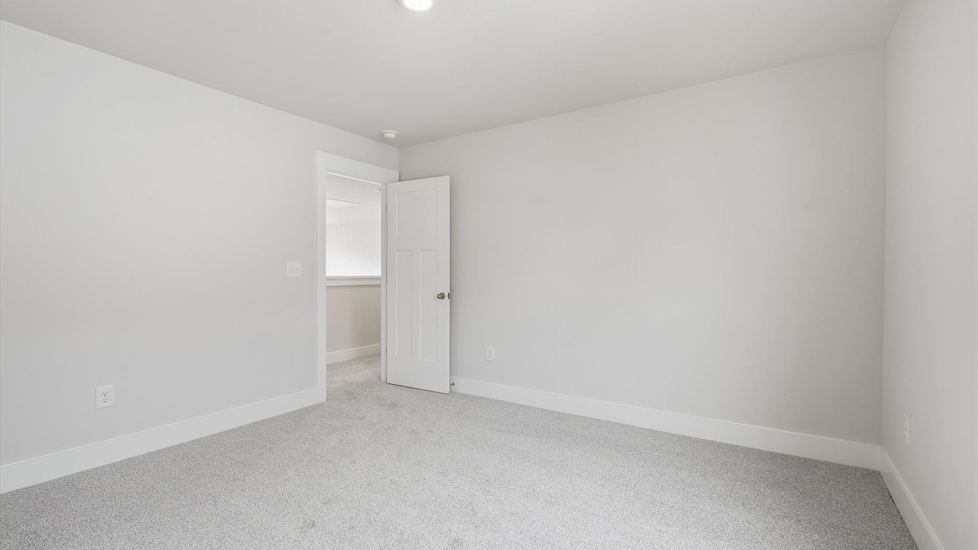 Inviting bedroom with tasteful finishes and large windows that create a fresh, open ambiance