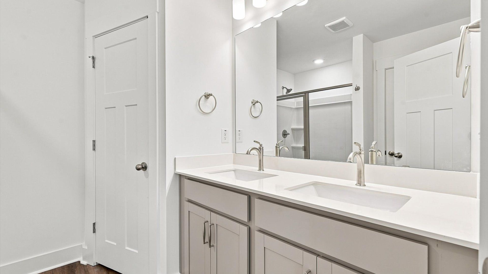 Spacious and modern primary bathroom with walk-in shower and first-class double vanity setup at Ransdell Pointe