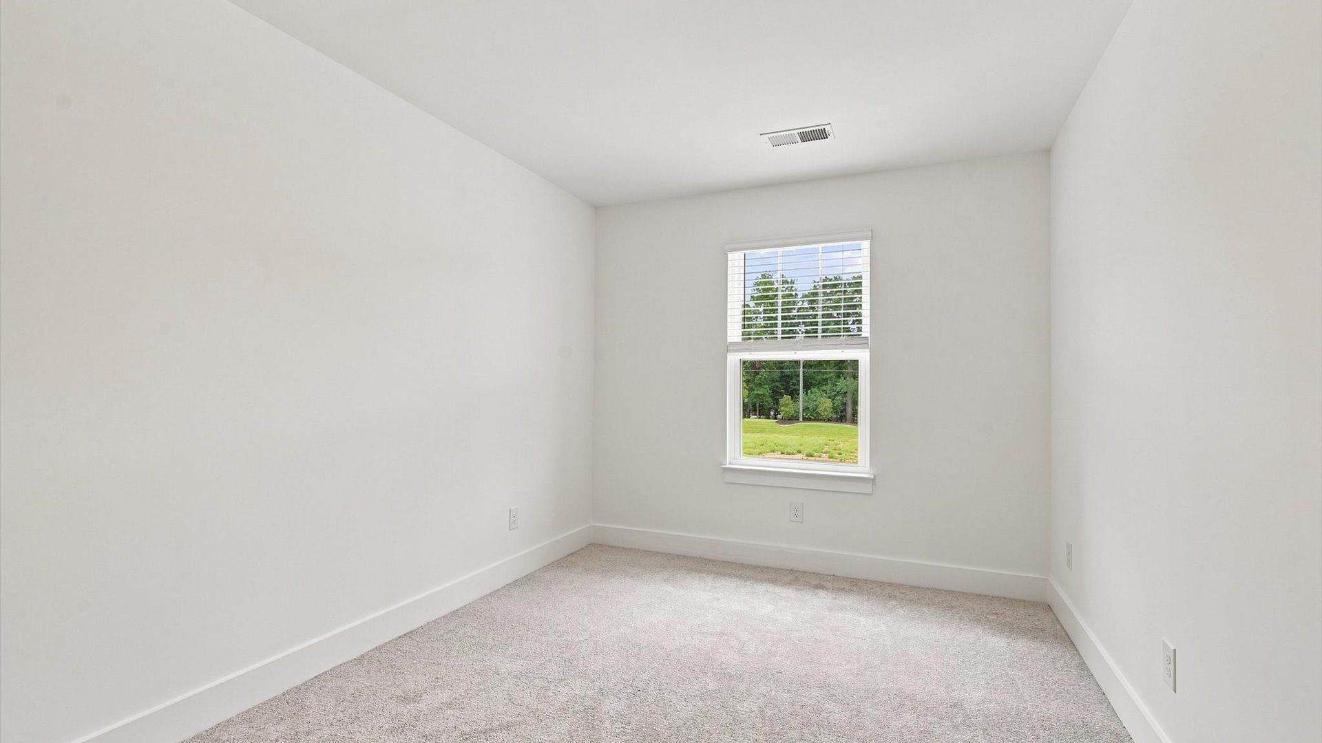 Inviting bedroom with tasteful finishes and a large window that create a fresh, open ambiance