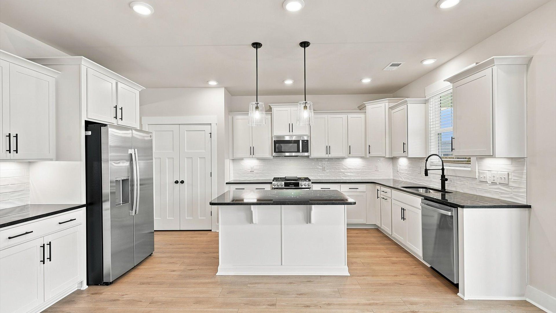 Elegant and compact island anchors this tasteful kitchen with high standards and timeless appeal by DRB Homes