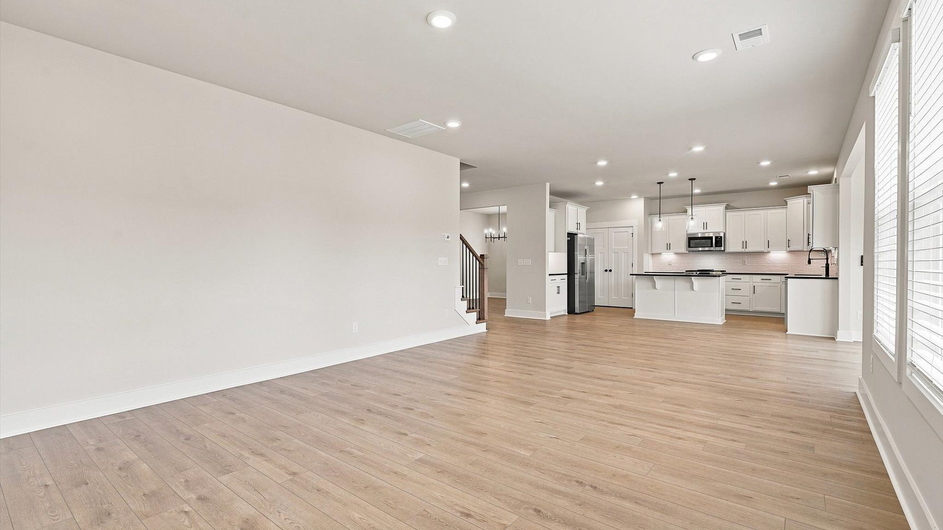 Spacious family room with rich hardwood flooring and elegant trim work in a reputable DRB Homes build