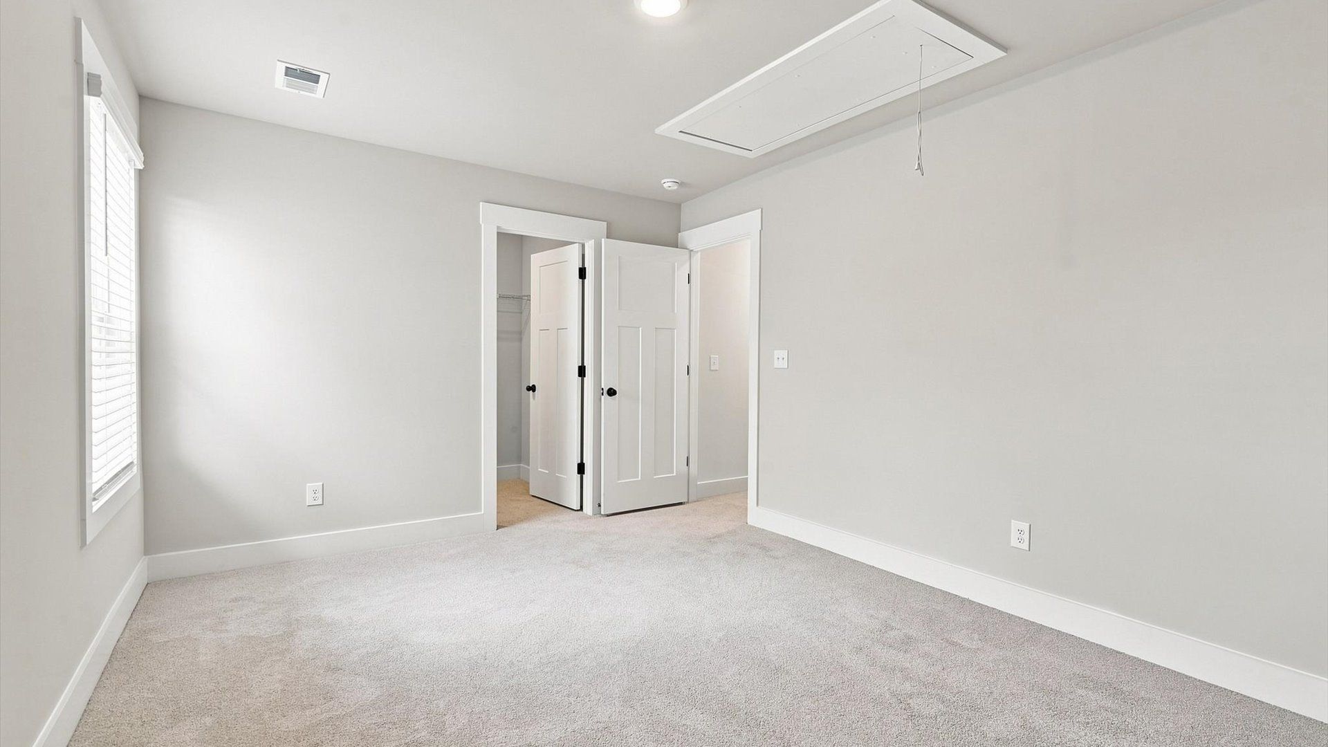 Elegant bedroom retreat featuring soft carpeting and a thoughtfully designed walk-in closet in Inman, SC