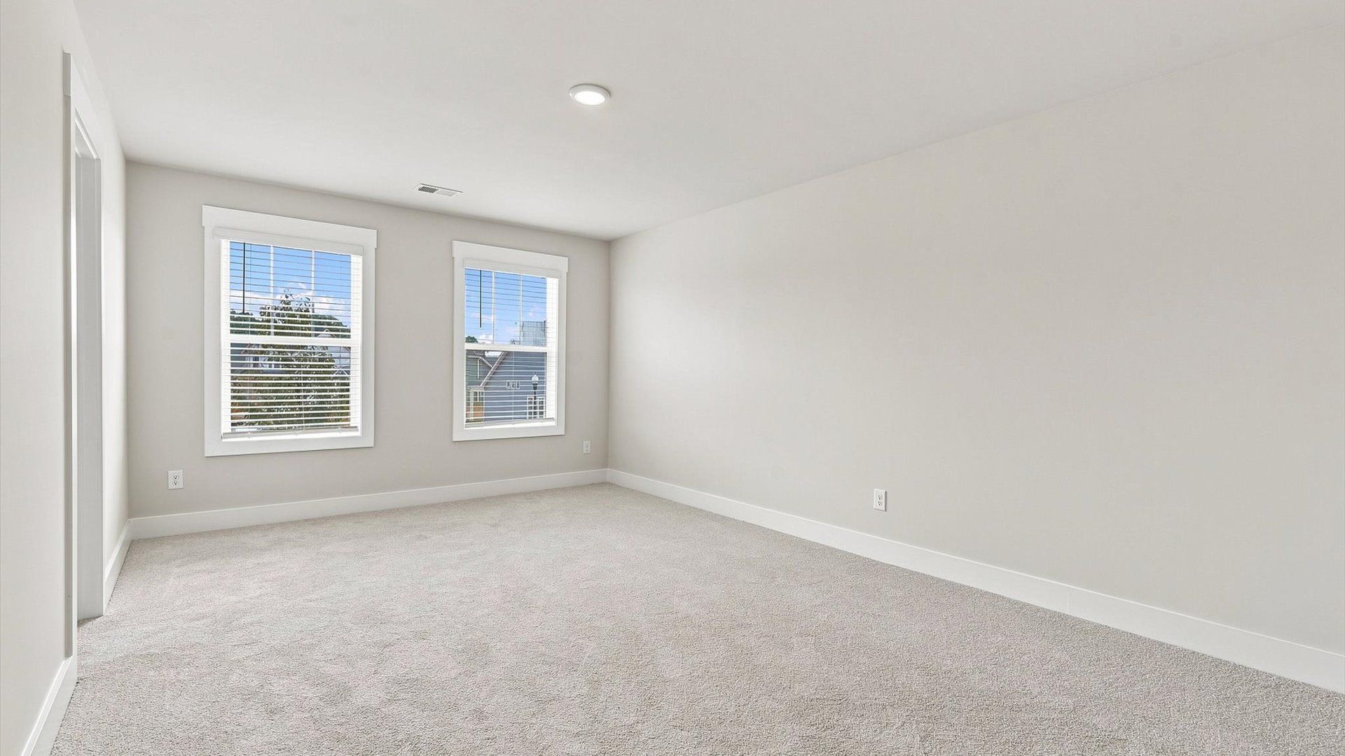 Tasteful bedroom with plush carpet, a walk-in closet, and large windows for abundant natural light at Walnut Ridge
