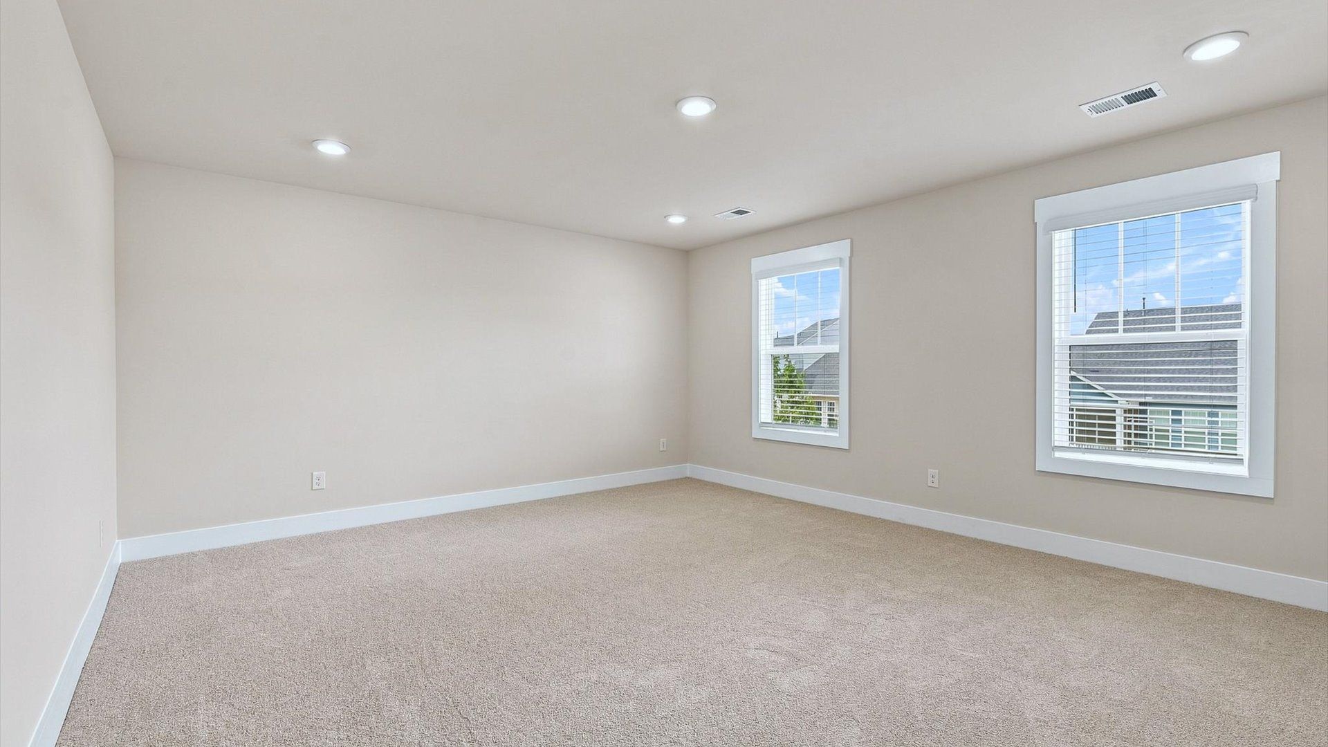 Serene and stylish primary bedroom featuring hardwood flooring and a thoughtful, modern layout
