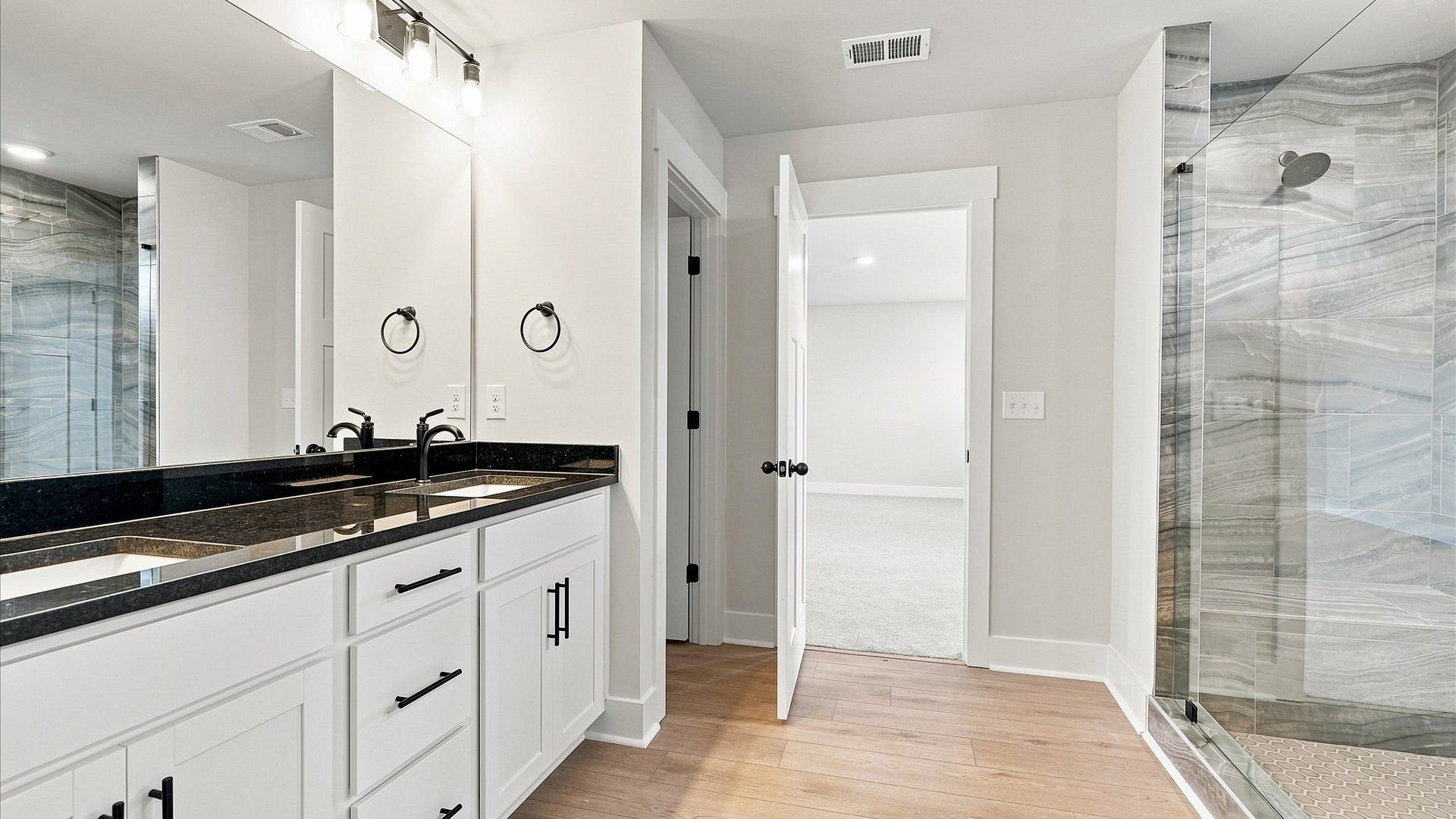 Accomplished design shines in this primary bath with dual vanity and a sleek walk-in shower