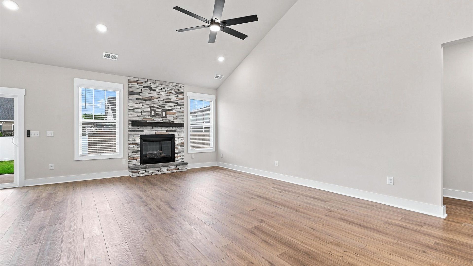 Spacious and stylish family room with two-story ceilings that create a bright and open atmosphere