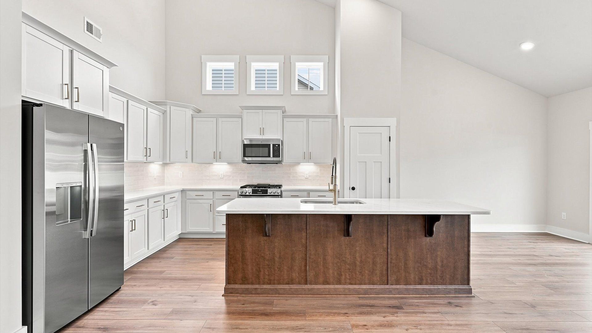 Elegant kitchen with large island and pendant lighting in this first-class DRB Homes design
