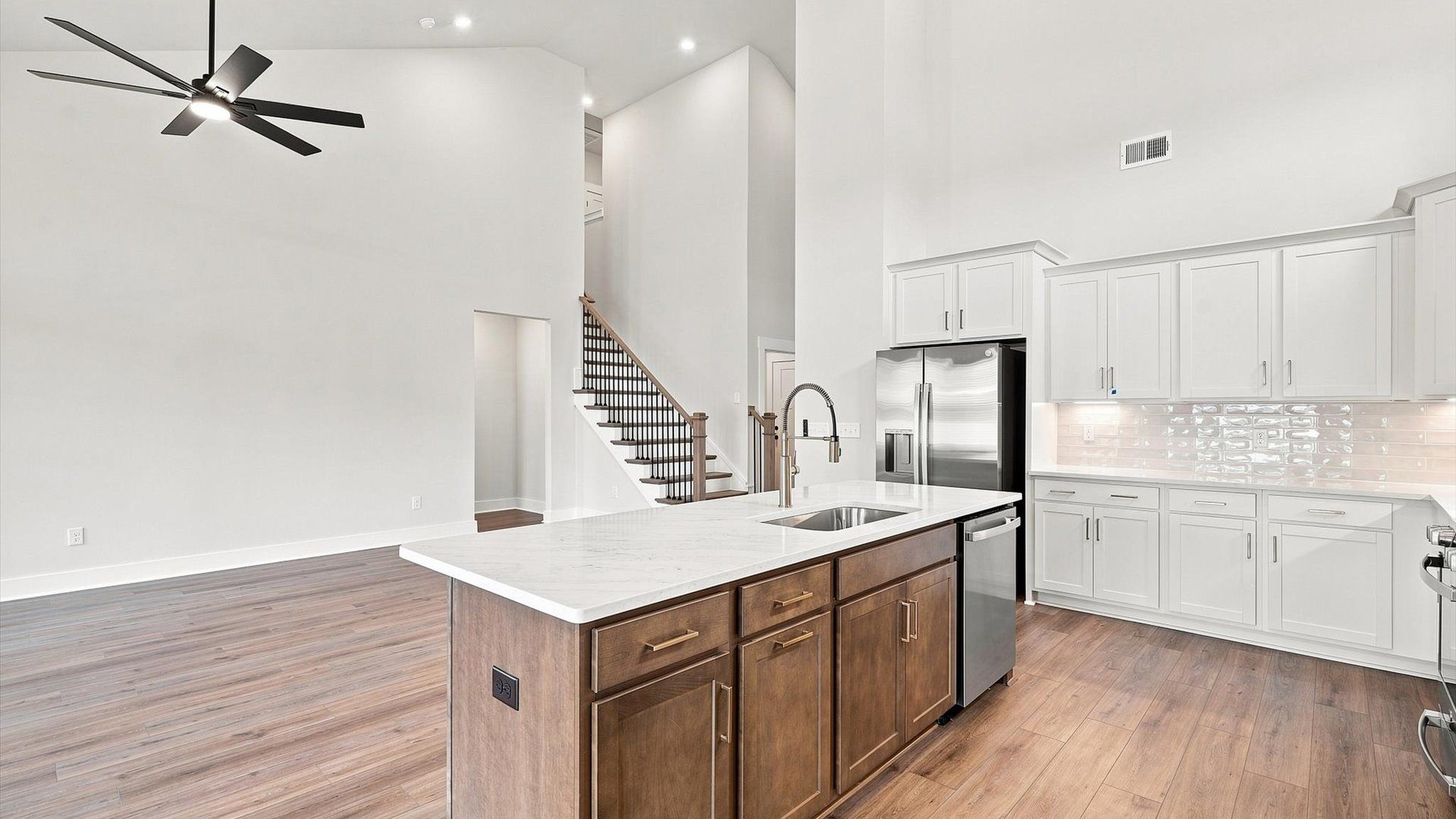 Highly skilled craftsmanship shines in this modern kitchen with high ceilings and a central island focal point