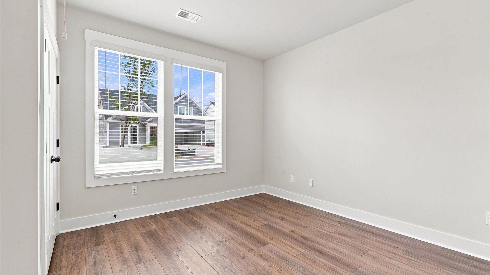 Functional secondary bedroom with hardwood flooring and modern touches in an exceptional layout by DRB Homes