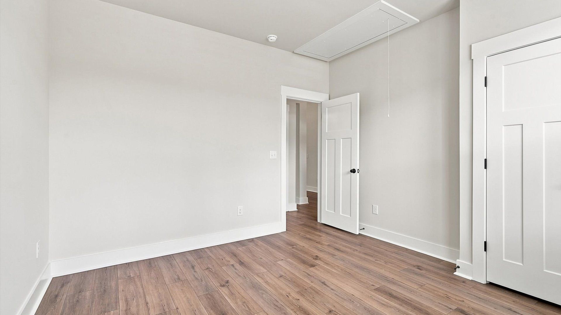 Superior comfort in a secondary bedroom with hardwood floors and an oversized walk-in closet