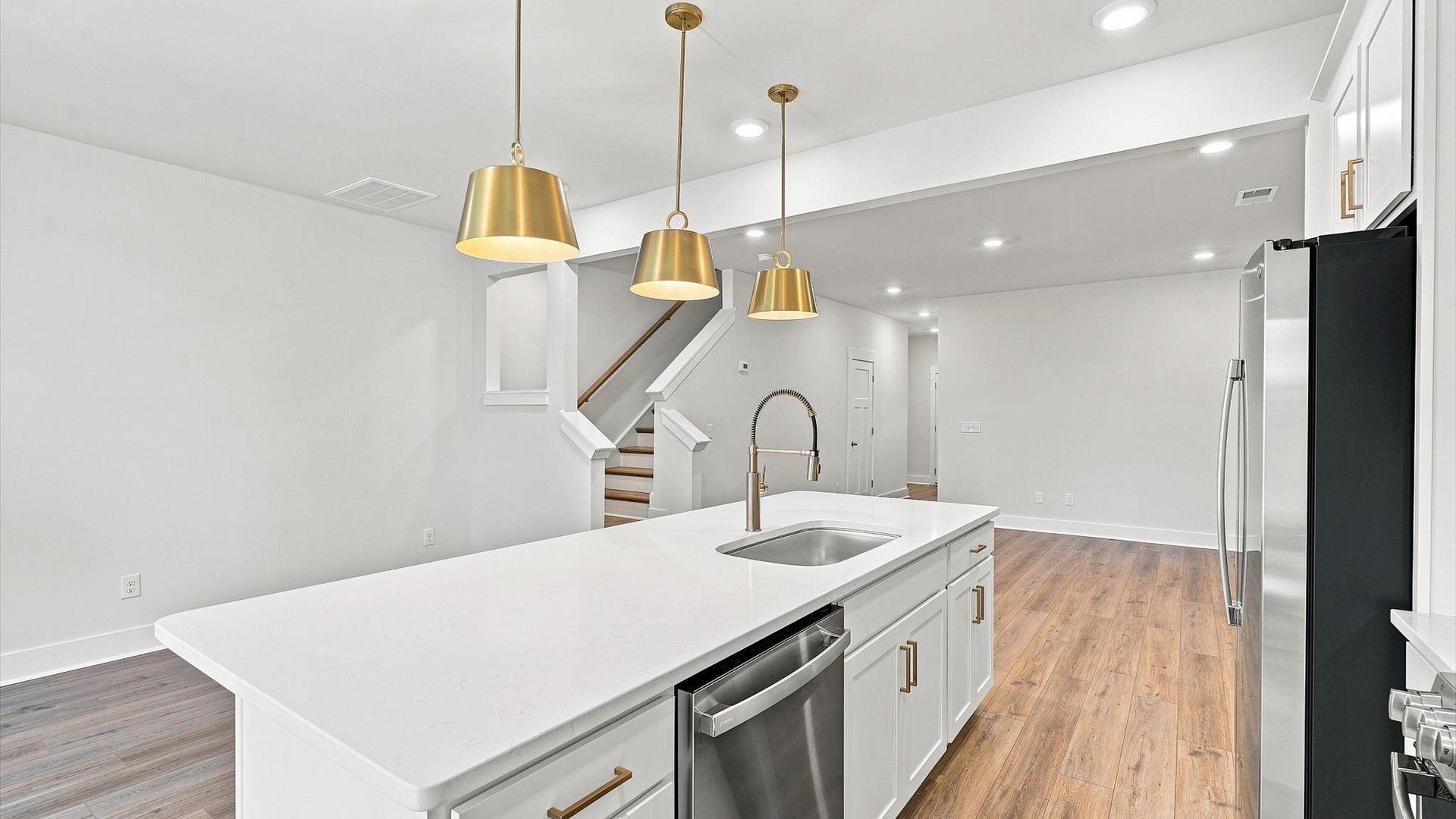 Exceptional culinary space with a striking 9-foot island and eye-catching pendant lights by DRB Homes