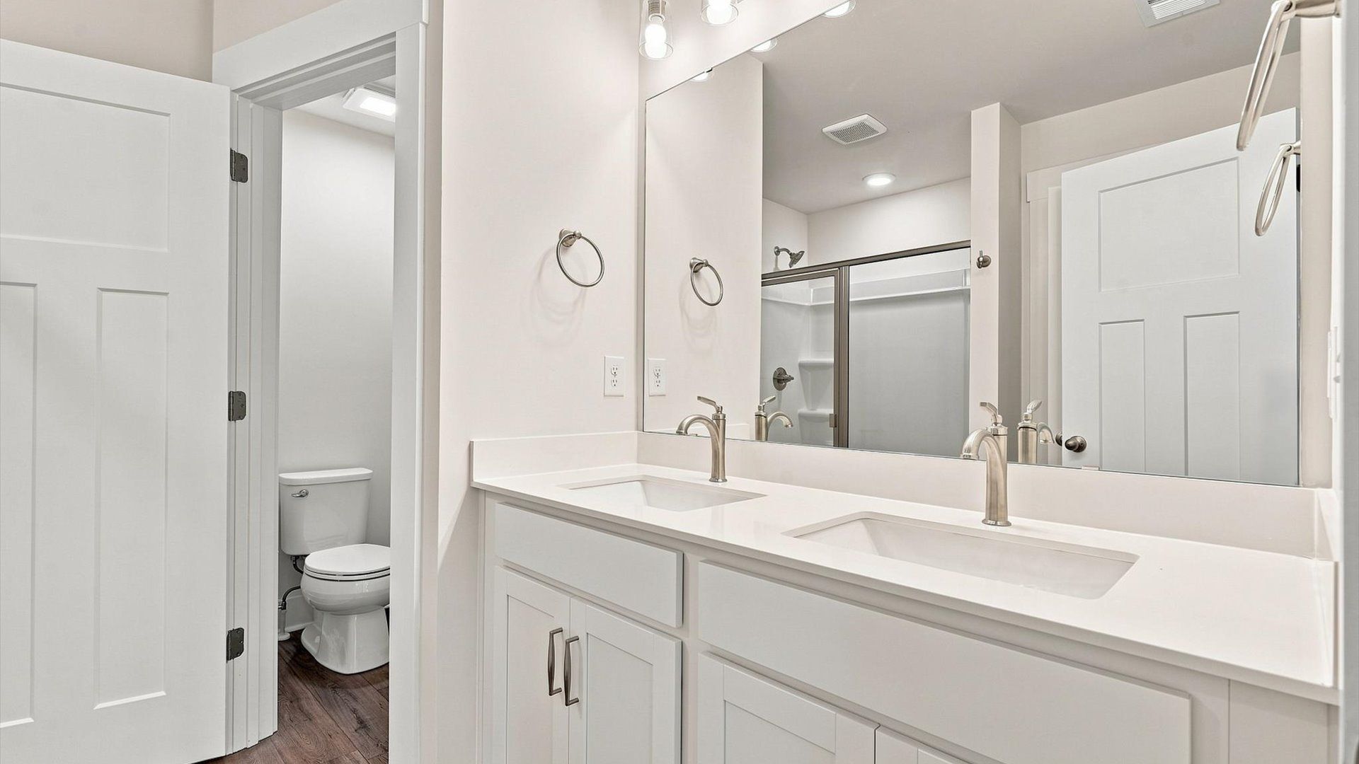 Accomplished design shines in this primary bath with dual vanity and a sleek walk-in shower in Spartanburg, SC
