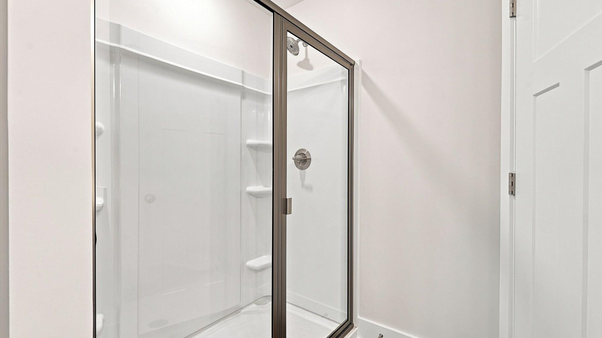 Sophisticated primary bathroom with a spacious walk-in shower and polished hardware by DRB Homes