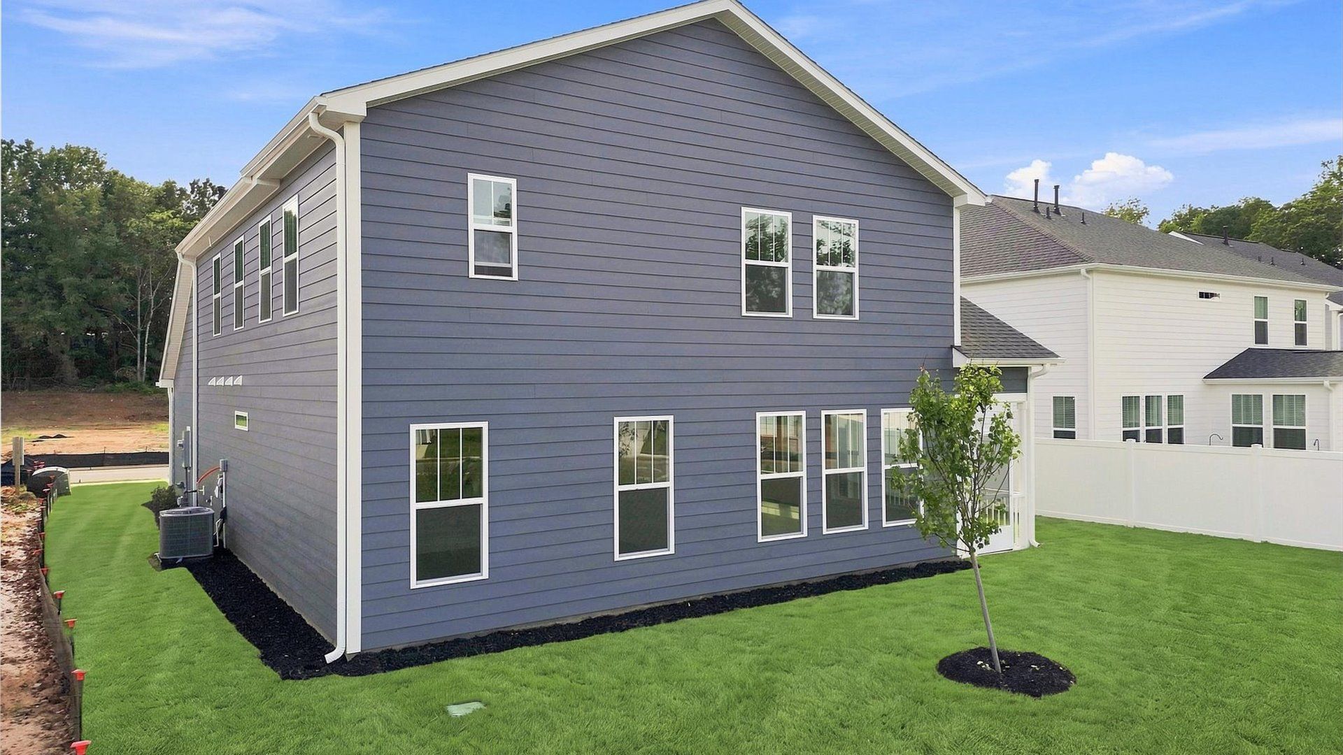 Vibrant rear outdoor space featuring a screened-in porch and exceptional craftsmanship at Creeks at Midway