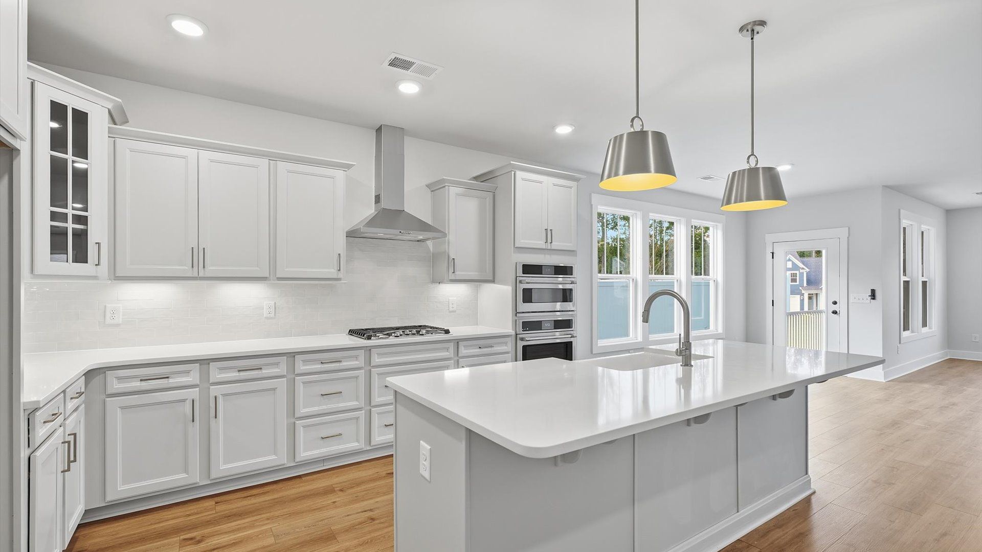 Elegant kitchen with large island and pendant lighting in this first-class DRB Homes design