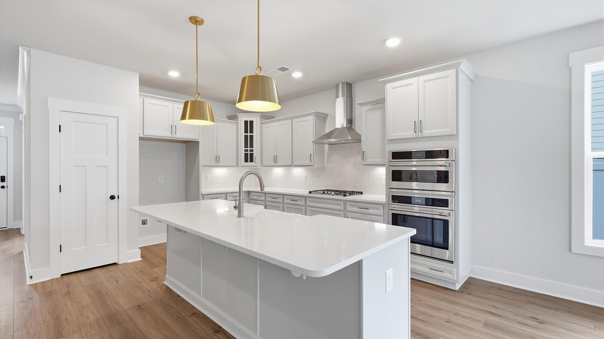 Tasteful design meets functional luxury in this kitchen with a 9-foot island and modern pendant lighting at Creeks at Midway