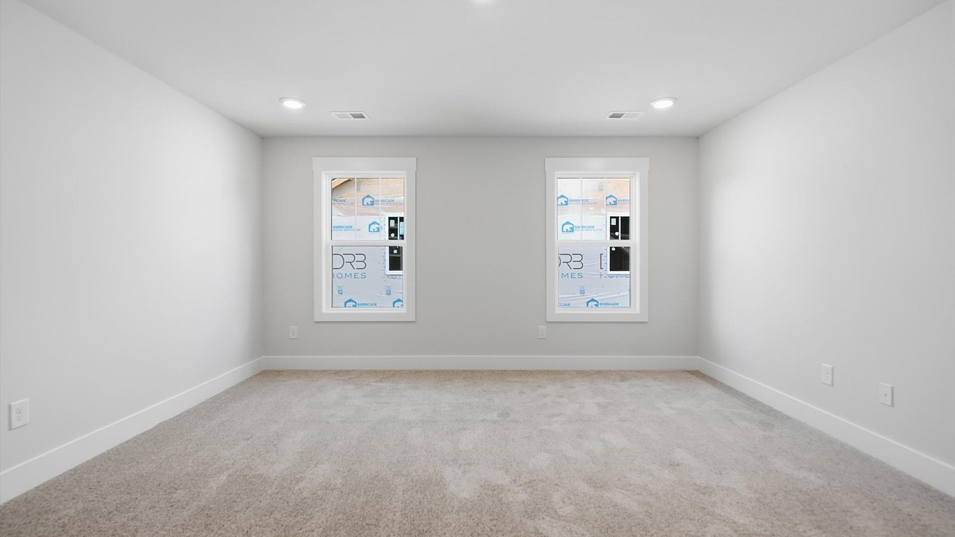 Accomplished upstairs game room with plush carpet and versatile functionality by DRB Homes