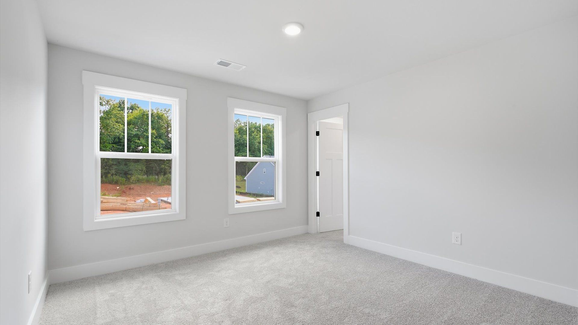 Highly functional bedroom with large windows, carpeted flooring, and tasteful finishes throughout in Anderson, SC