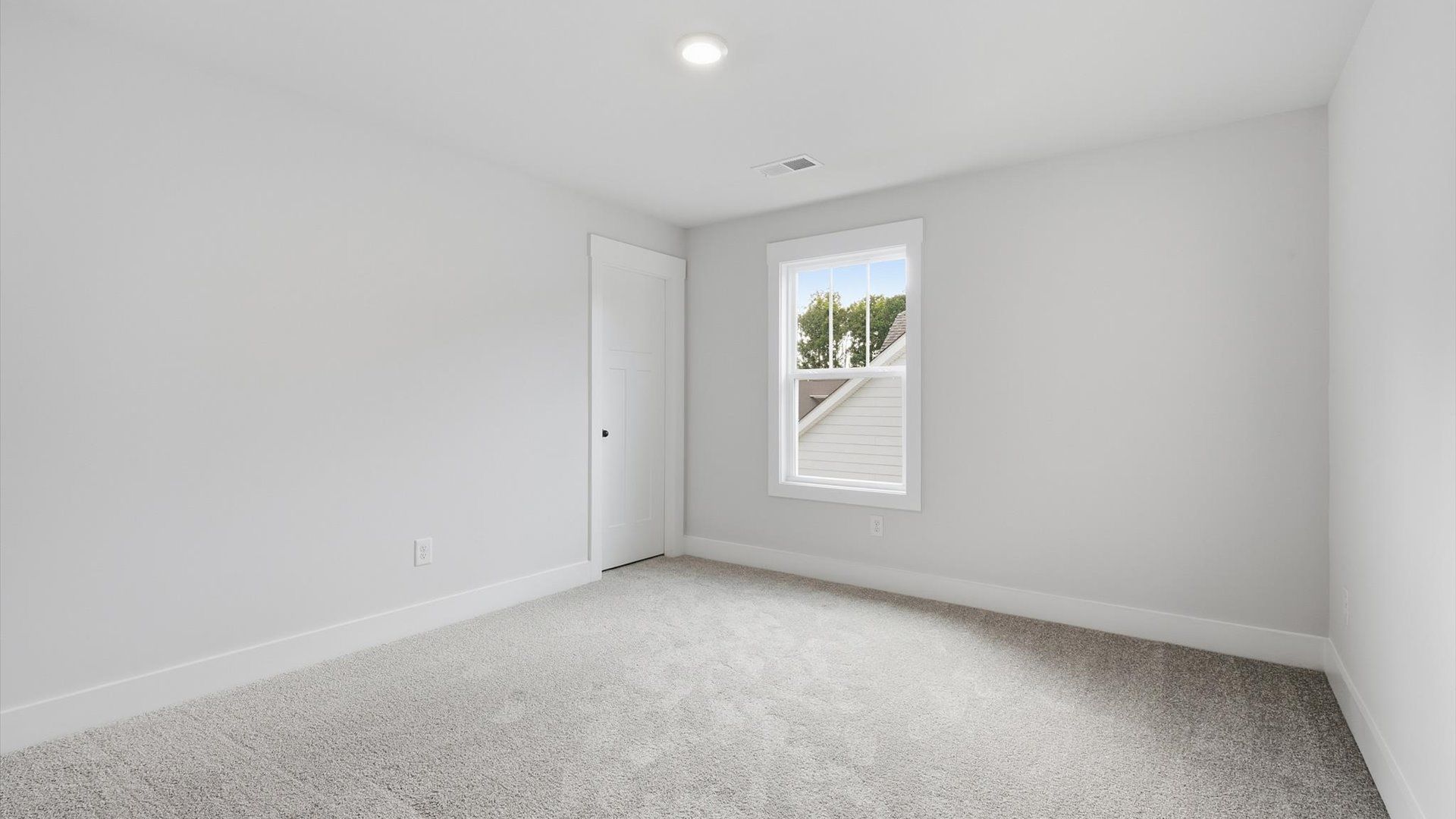 Refined bedroom design with a large window for daylight-filled mornings and peaceful views by DRB Homes