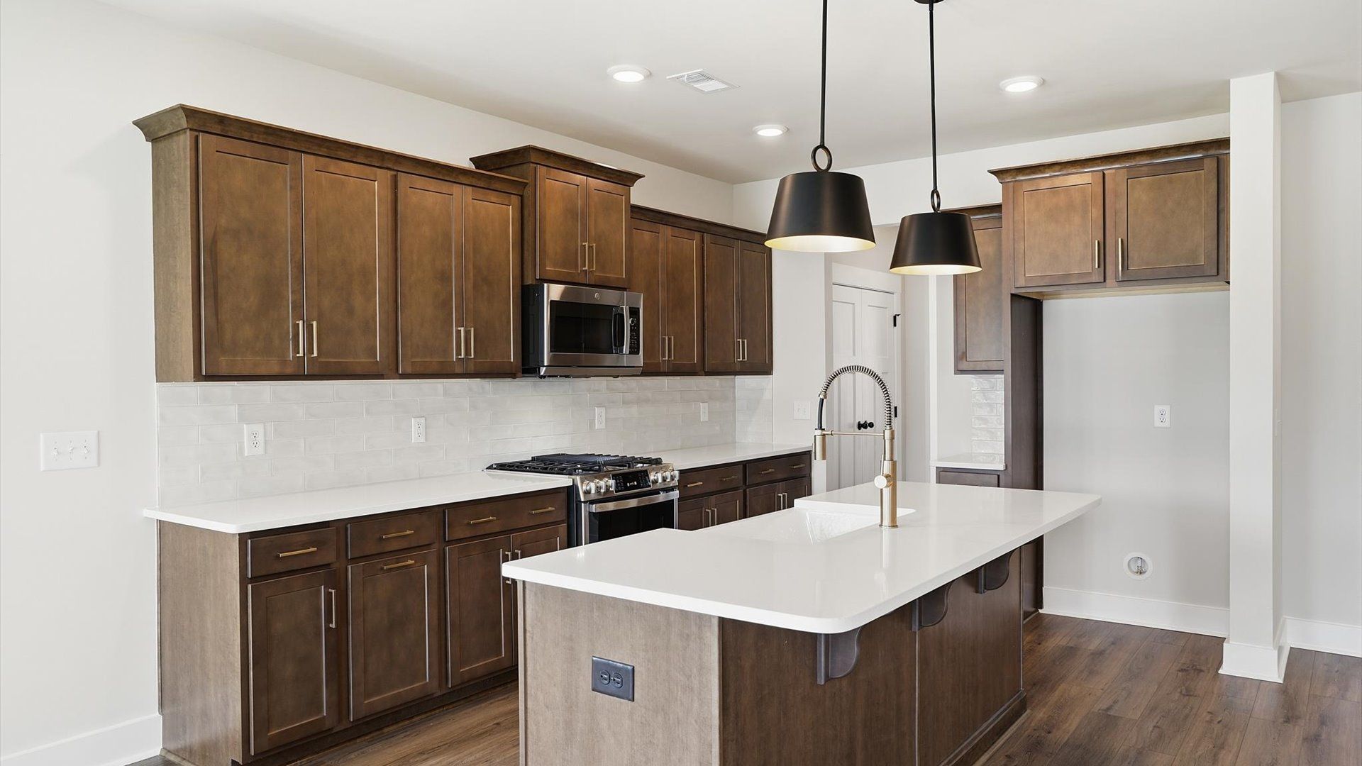 Well-designed kitchen with a center island and tasteful finishes that elevate everyday living by DRB Homes
