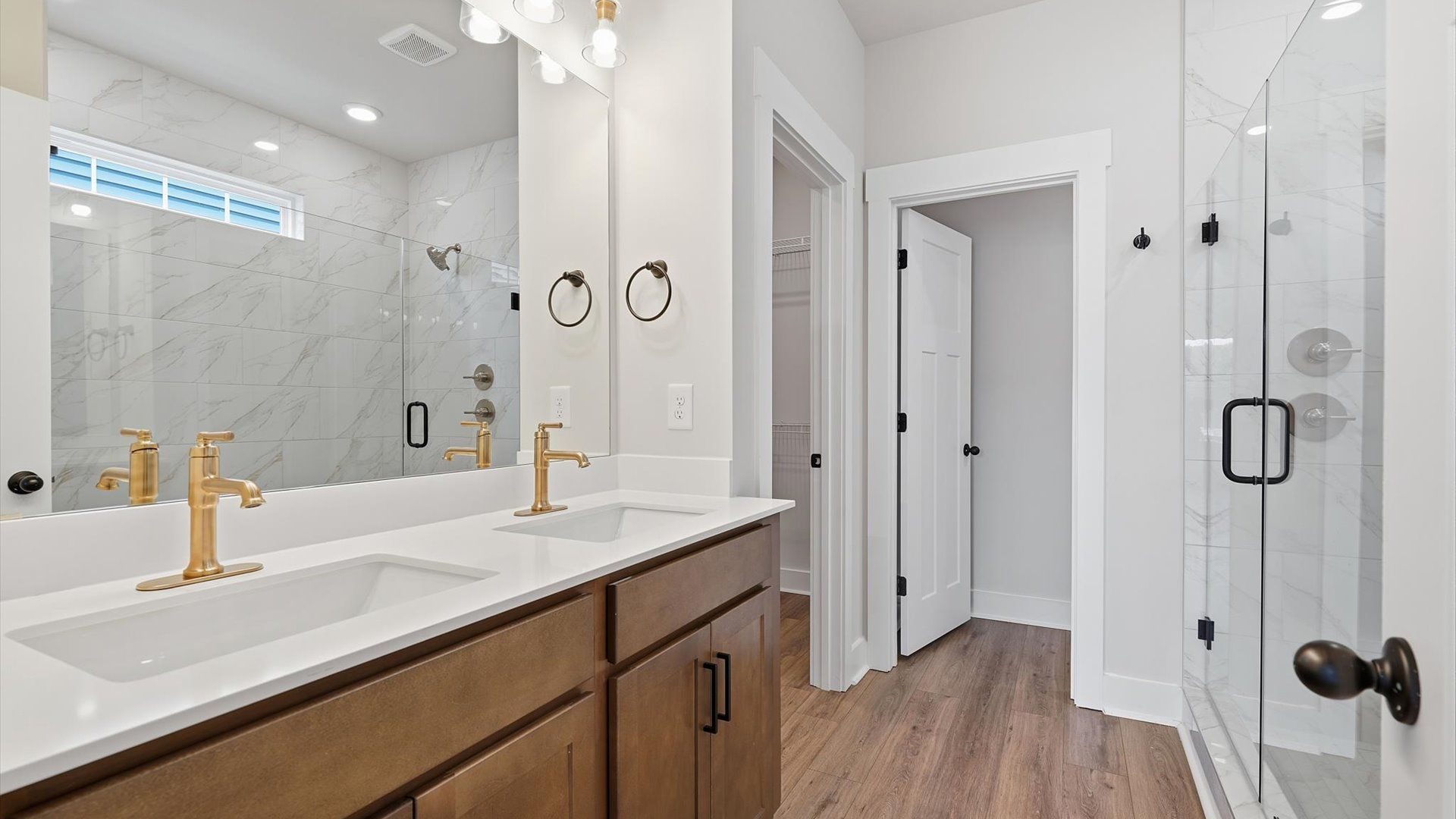 Exceptional en-suite with dual vanity and glass-enclosed walk-in shower for superior everyday comfort by DRB Homes