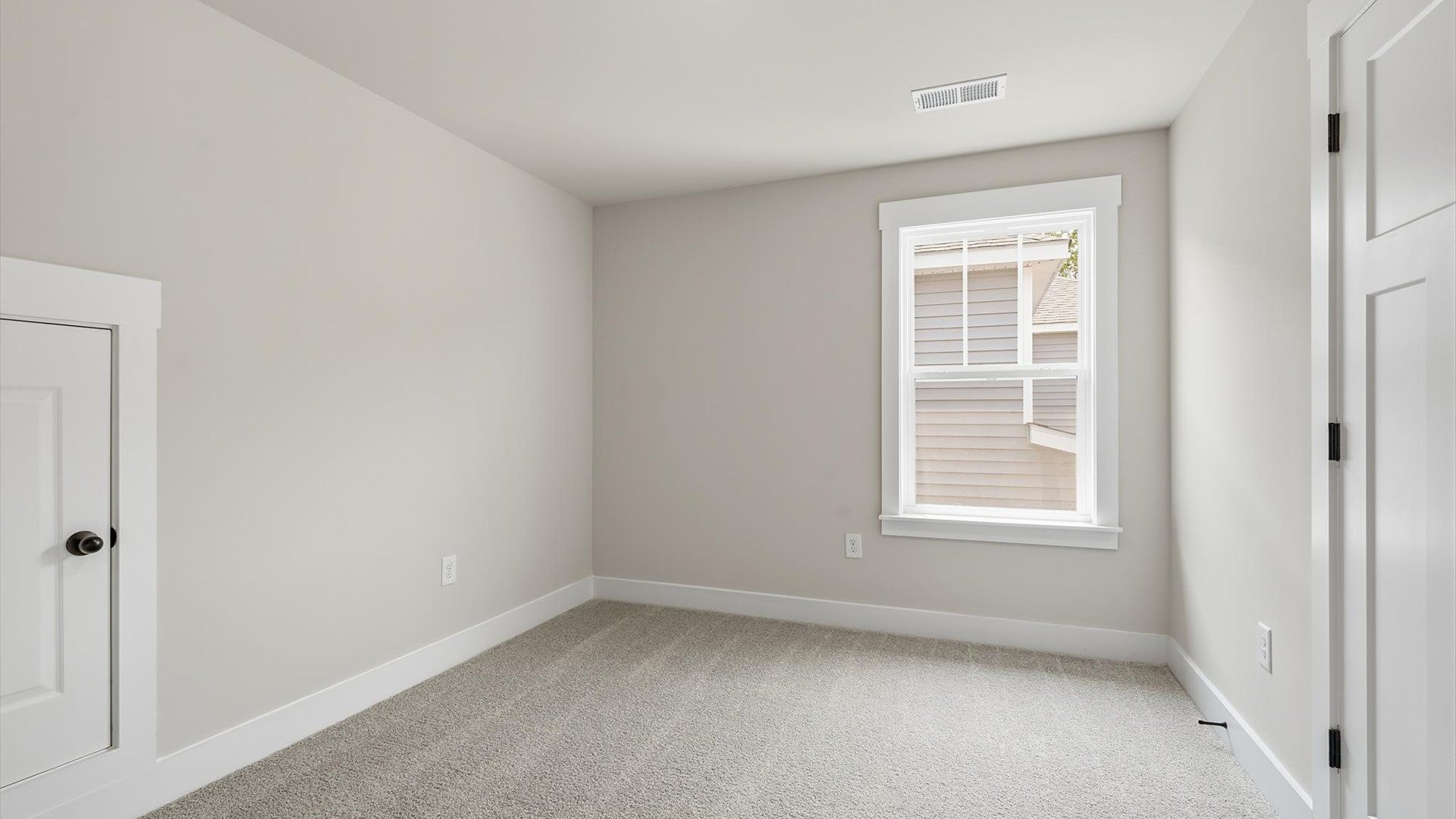 Bright and serene bedroom with comfortable carpeted flooring and large windows for vibrant light