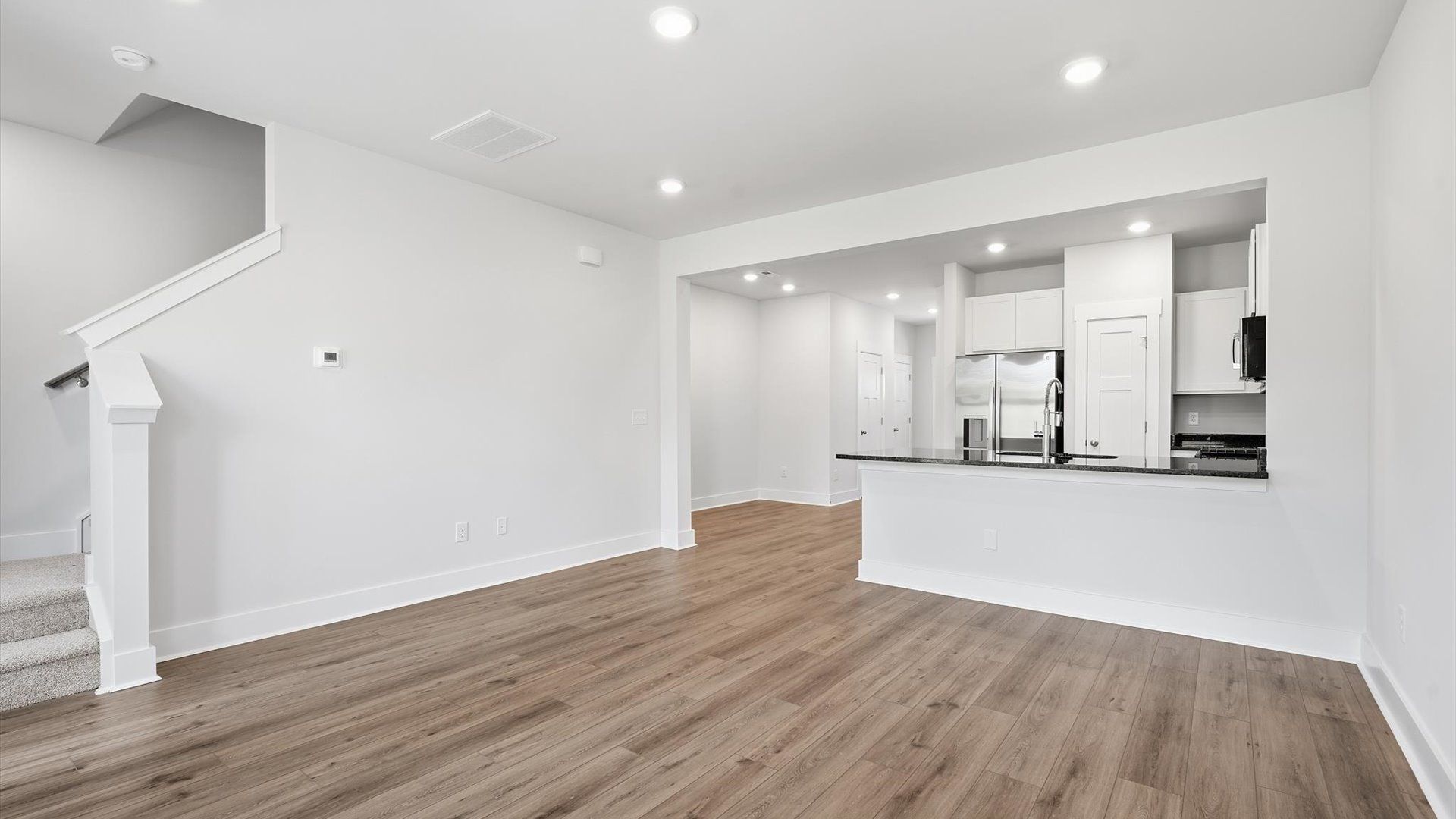 Elegant family room featuring hardwood flooring, large windows, and thoughtful architectural detail